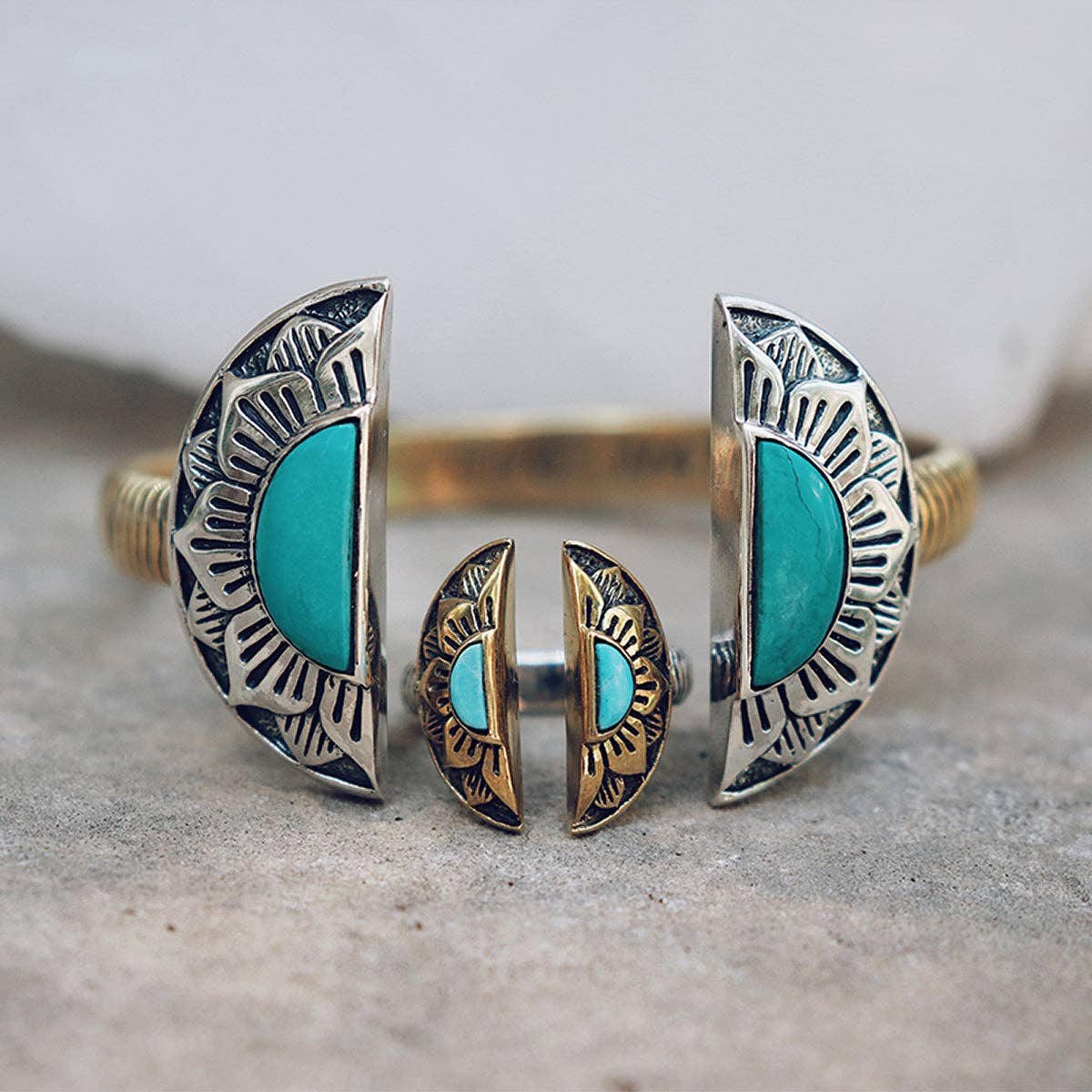 A silver and gold cuff with two turquoise half-moon ends and engraved sunbursts, shown on stone—pair it with bahgsu jewels’ Natural Mystic Ring - Turquoise for a bold, coordinated style.