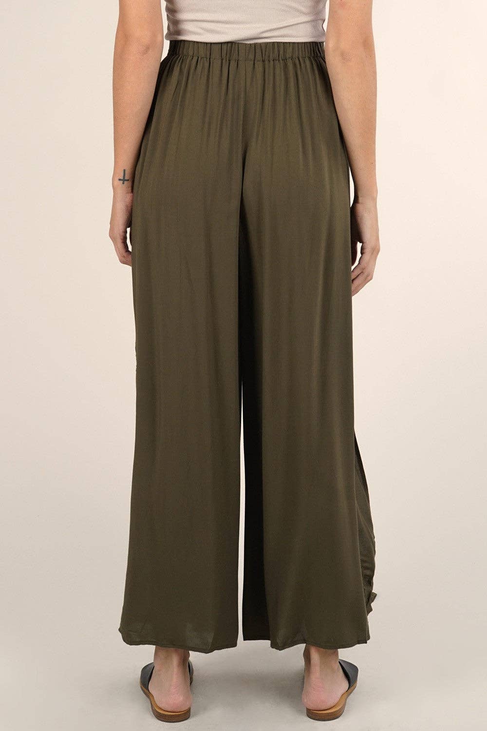 Back view of a person wearing olive green Boho Beach Light Weight Wrap Pant with wide legs and side slit.