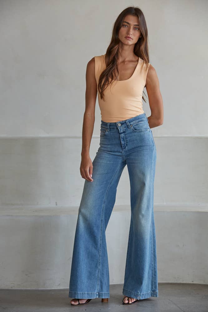 Woman wearing a peach Double Layered Seamless Top paired with high-waisted wide-leg blue jeans and sandals
