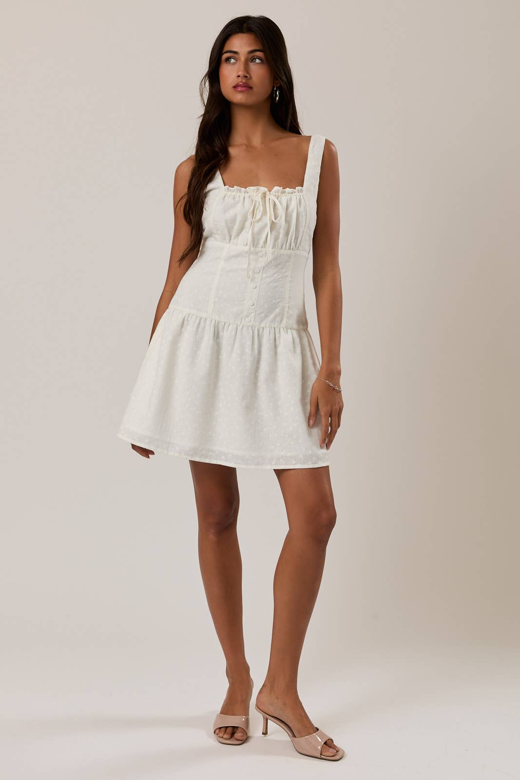 Woman wearing a white Shirred Neck Low Waist Mini Dress with a square neckline and sleeveless design.
