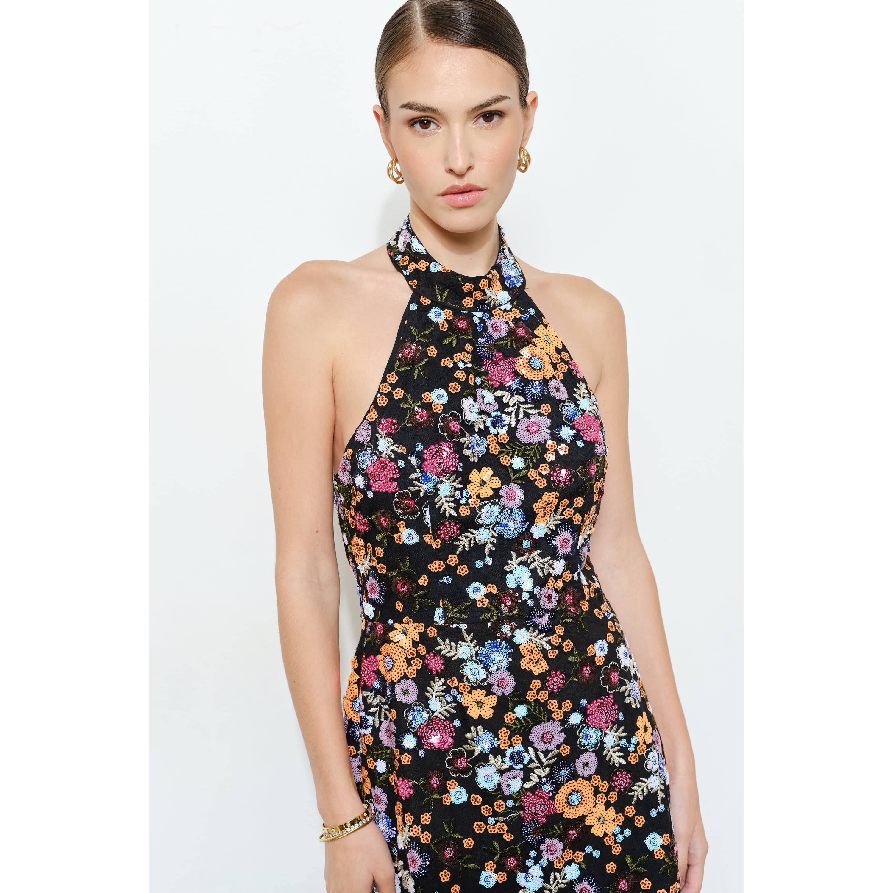 Model wearing a Floral Sequins Embellished Halter Neck Mini Dress with colorful floral patterns on black fabric