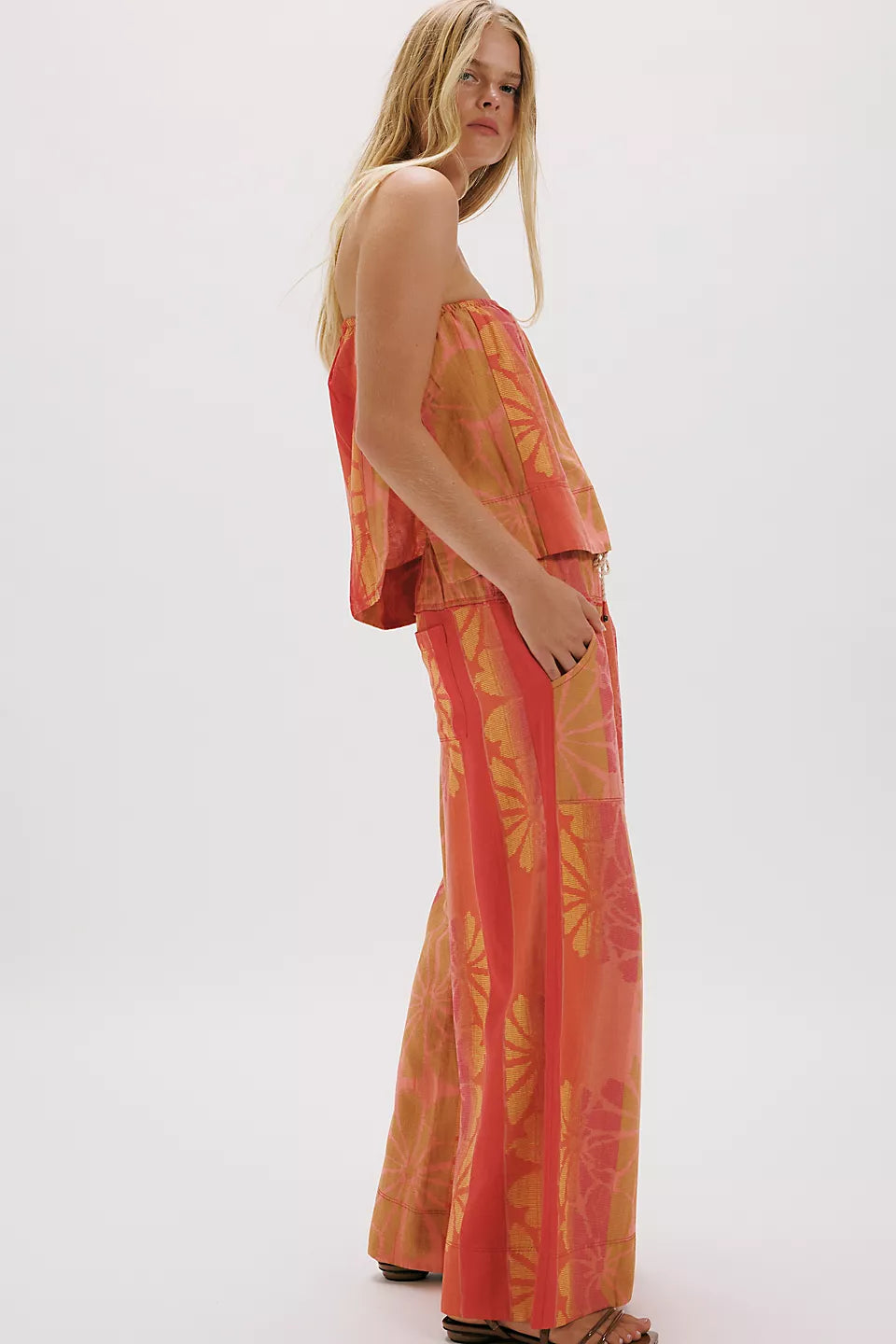Woman wearing vibrant coral and mustard top and wide-leg pants in FREE PEOPLE DEVELLA SET with floral patterns
