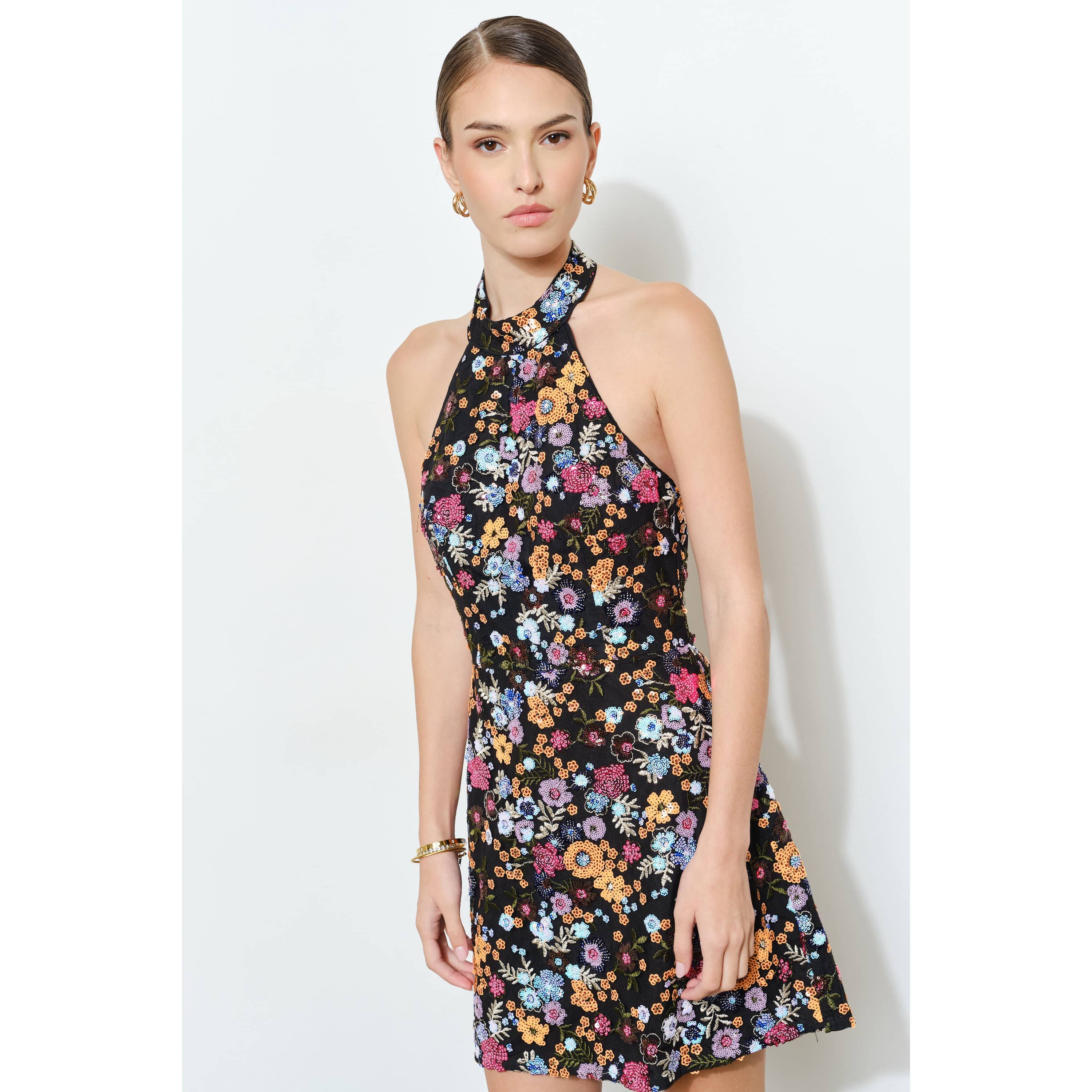 Woman wearing Floral Sequins Embellished Halter Neck Mini Dress with vibrant floral pattern and sleek silhouette
