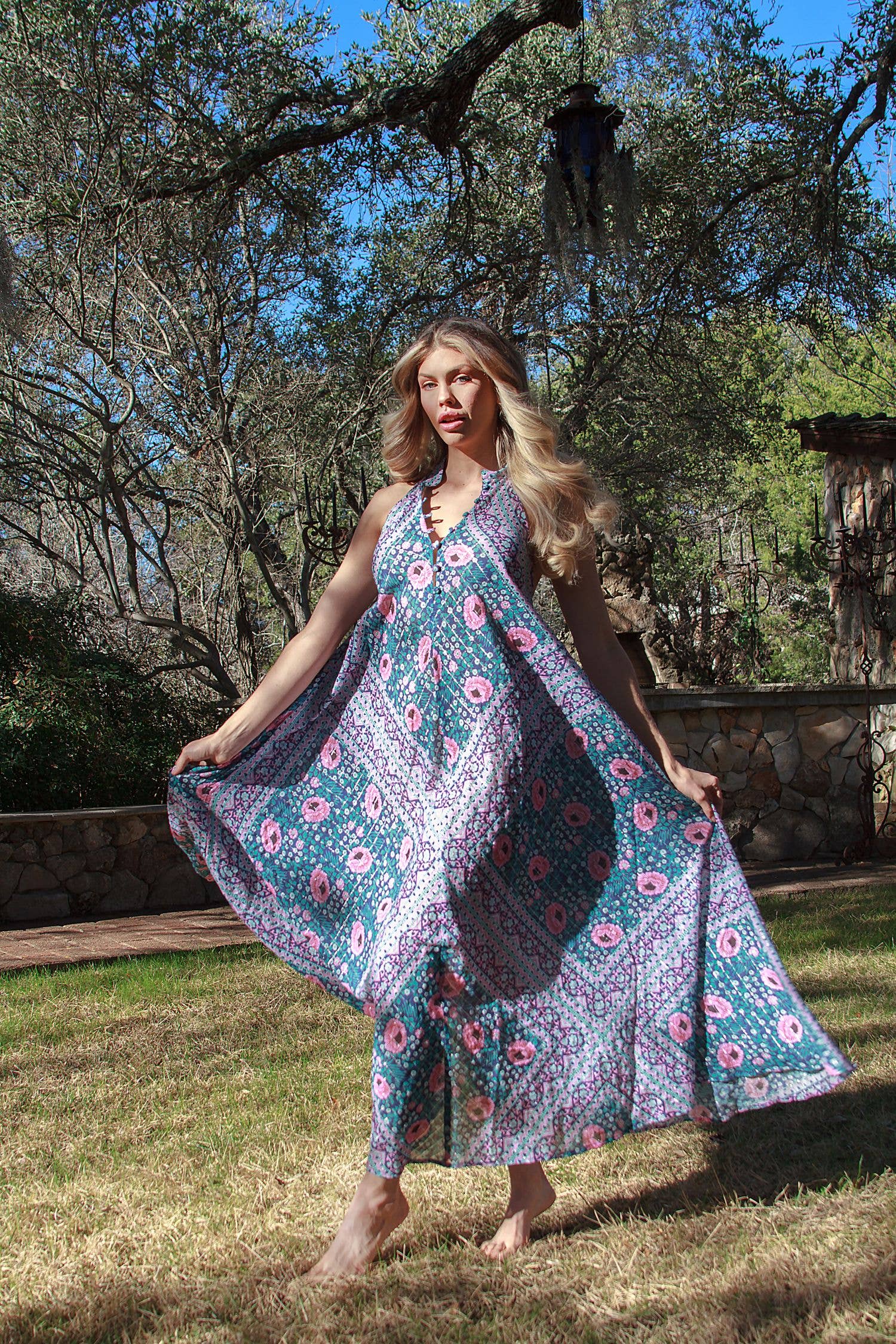Woman outdoors wearing a flowing Cotton Glendora Maxi Dress with colorful floral and geometric patterns