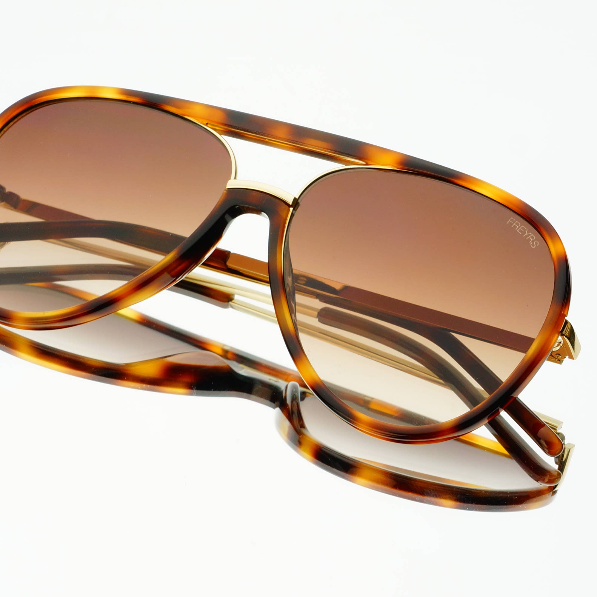 The Shay (NEW) Unisex Aviator Sunglasses by FREYRS Eyewear feature brown tortoiseshell biodegradable acetate frames, gradient brown nylon lenses, German hardware, and a gold bridge, shown on a white background.