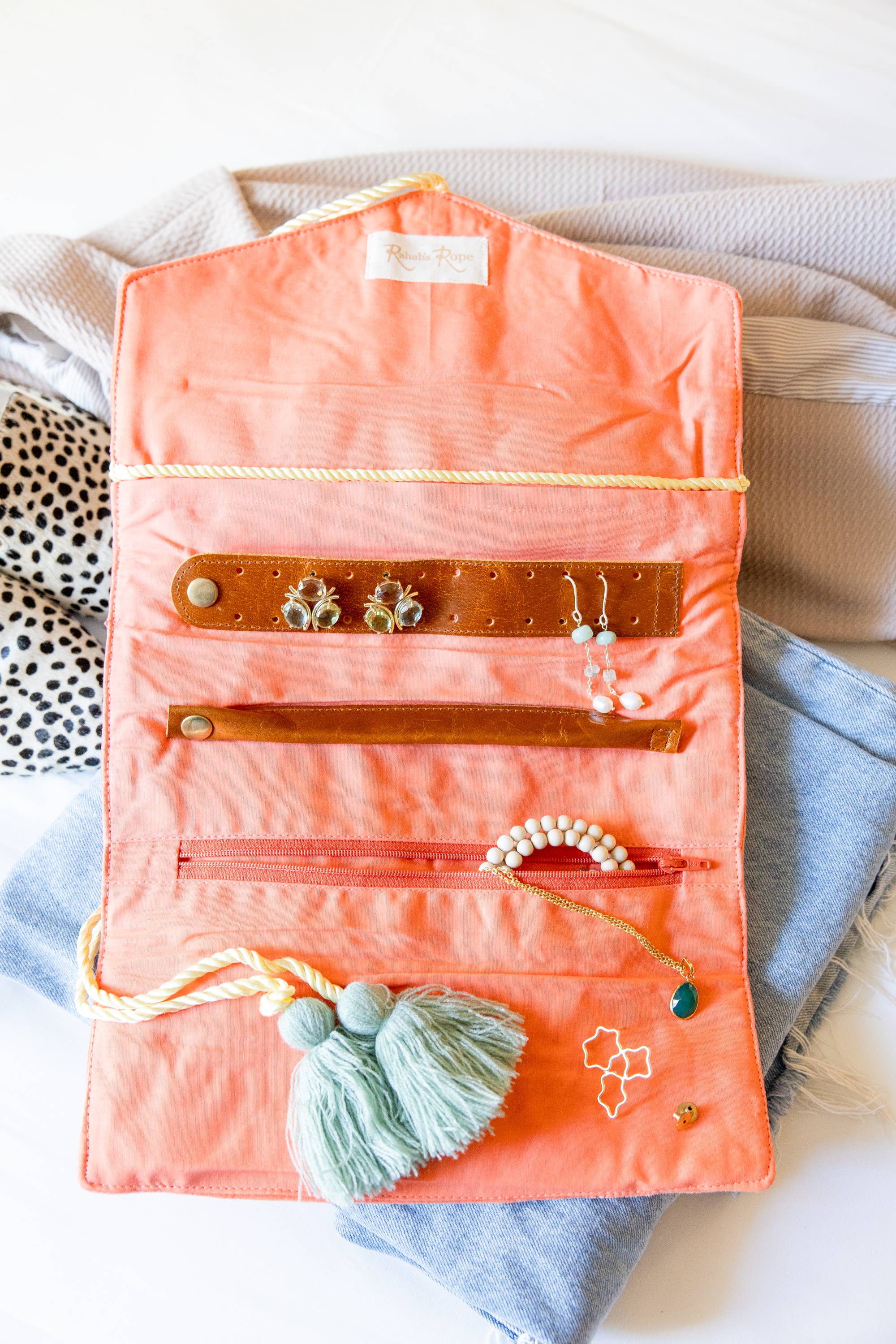 Embroidered Velvet Jewelry Organizer-Coral open with earrings, bracelet, necklace, and tassel details on soft fabric background