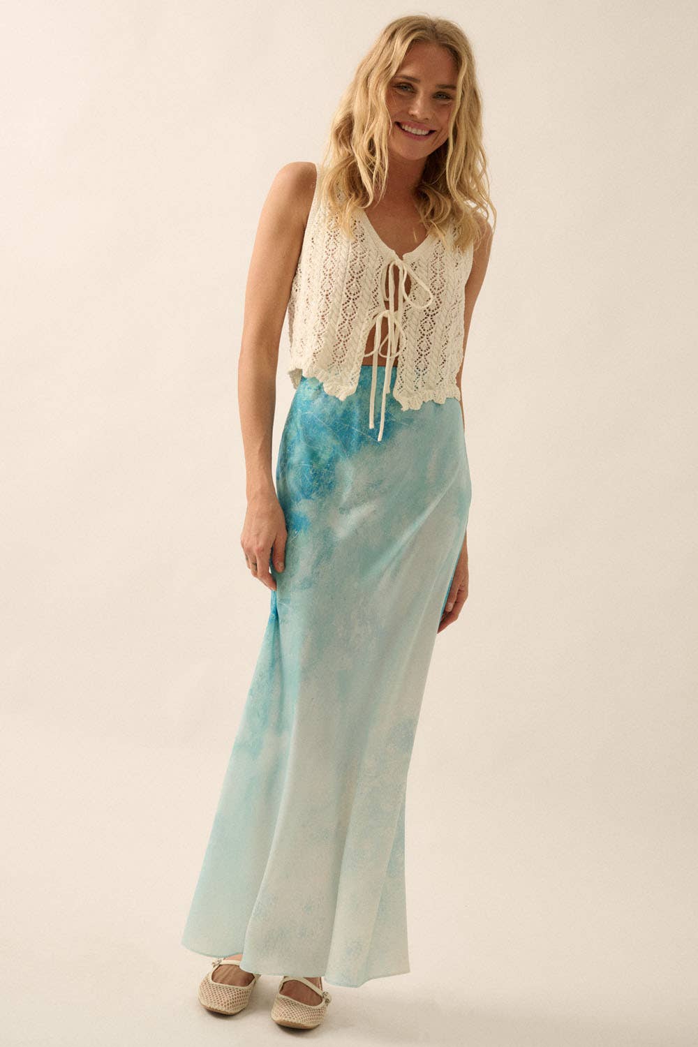 Woman wearing a light blue Tie Dye-Print Satin Bias-Cut Maxi Skirt paired with a white crochet sleeveless top