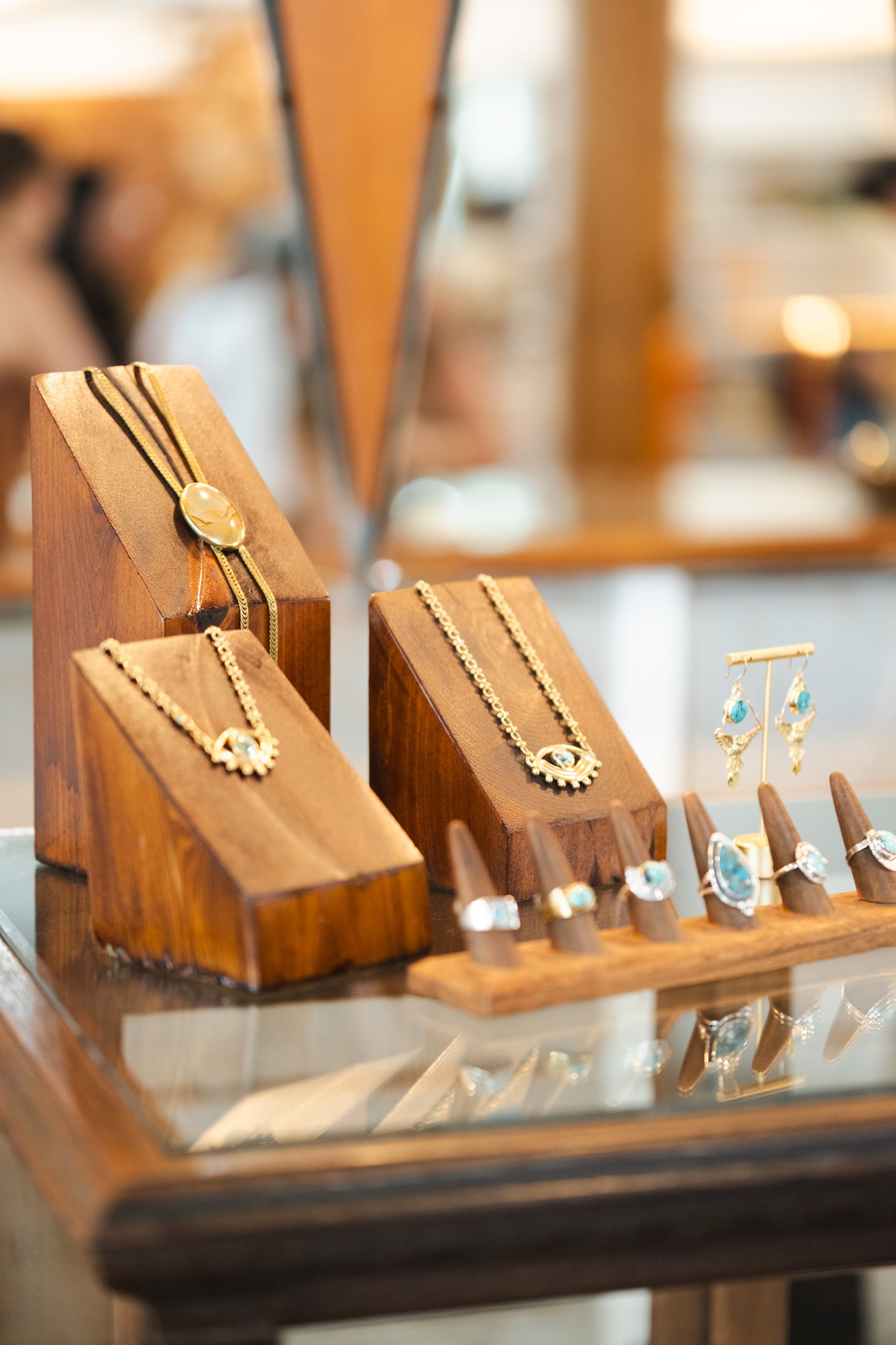 Jewelry display with necklaces and earrings on wooden stands.