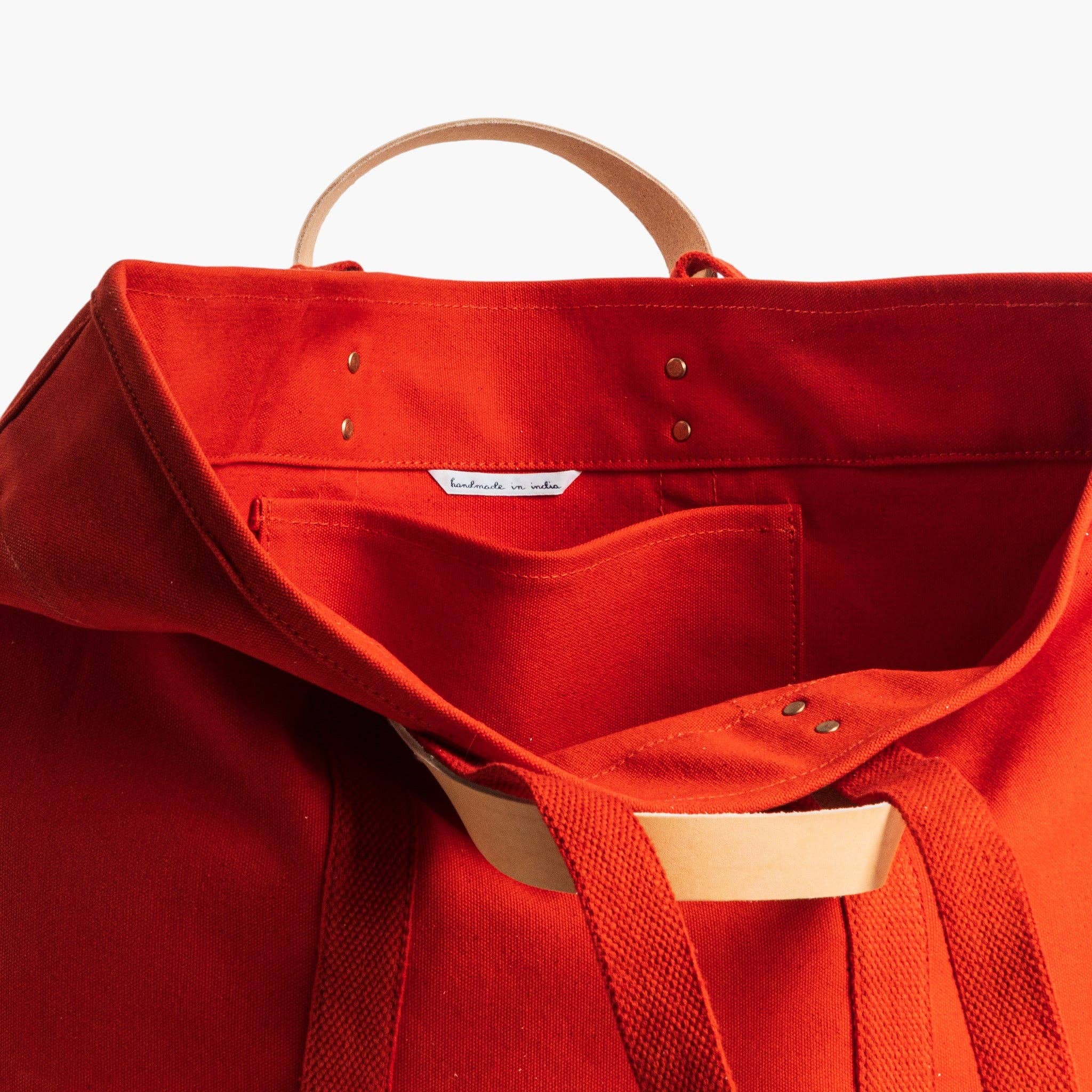 Large East West Tote | Persimmon in vibrant orange canvas with natural leather handles and interior pocket detail