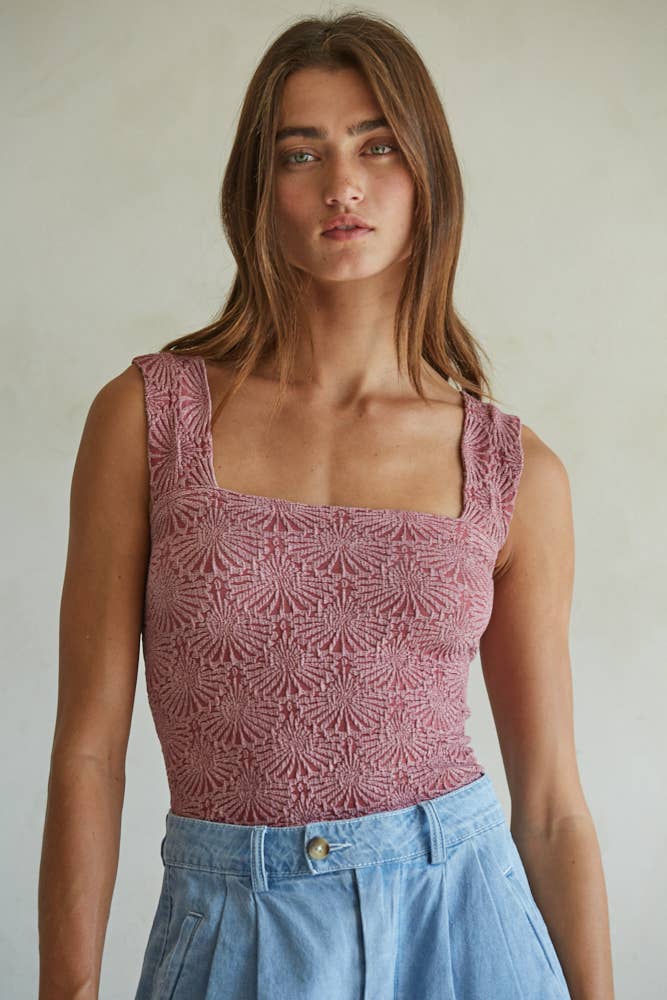 A woman with long brown hair wears the By Together Knit Modal Nylon Spandex Seamless Jacquard Tank in dusty pink and high-waisted light blue pants, standing against a neutral background.