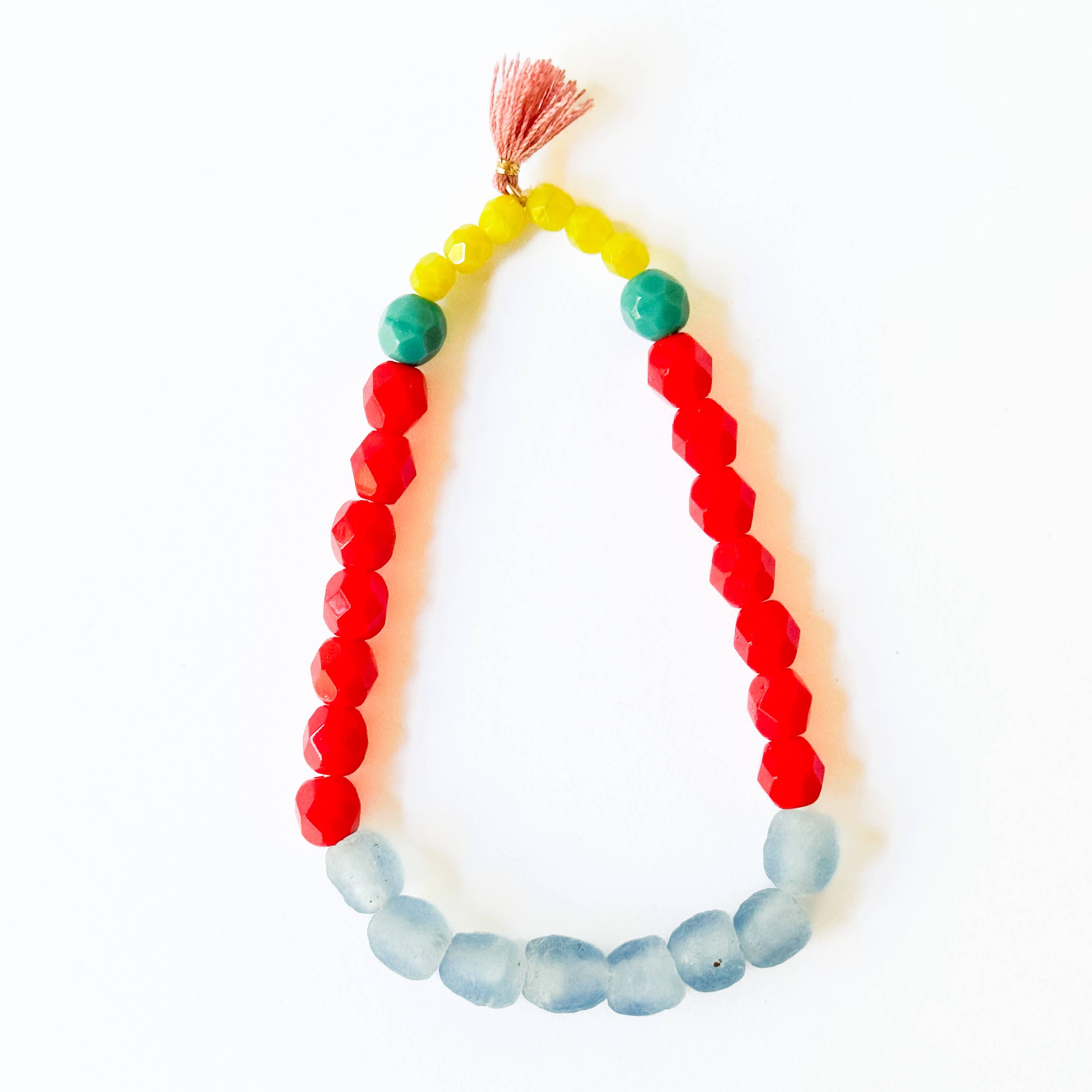 Multicolor Recycled African Glass And Mixed Bead Bracelet with red, yellow, blue, and green beads and a small tassel closure