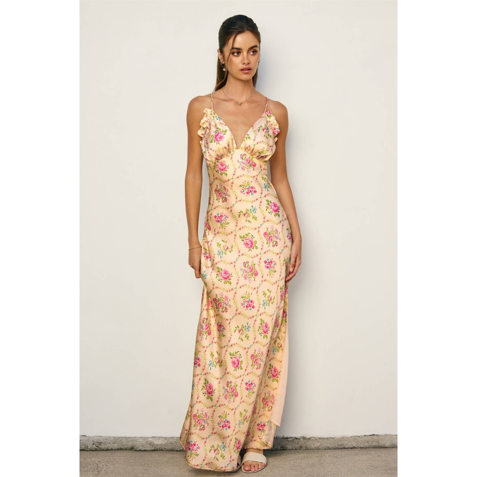 Woman wearing a floral Eternal Afternoon Ruffled Triangle Bust Maxi Dress with delicate straps and ruffle details