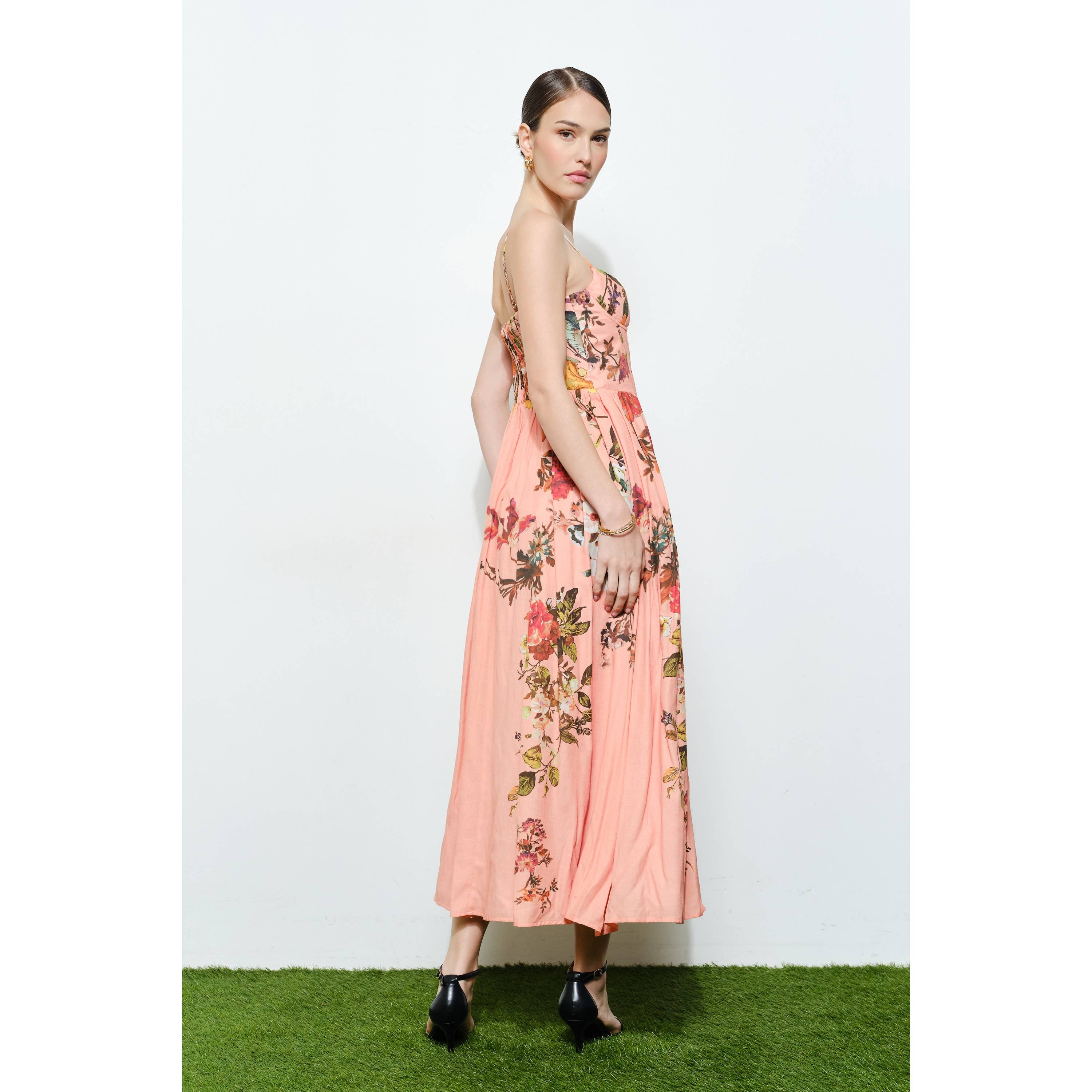 Woman wearing a flowy Vintage Floral Sweetheart Maxi Dress with pink and floral patterns standing on grass