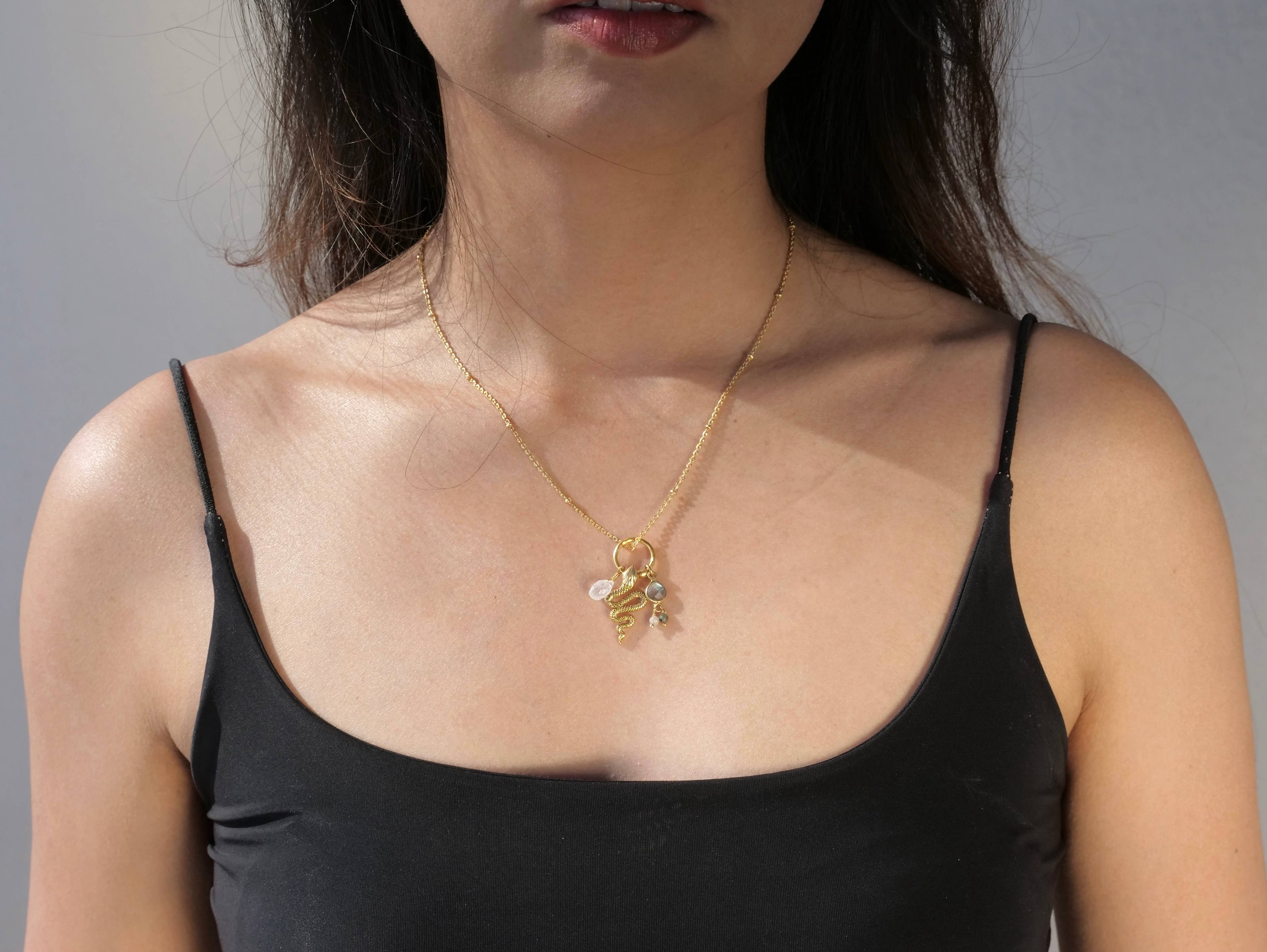 Gold Plated Snake & Gemstone Charm Necklace worn on model with black tank top highlighting delicate jewelry design