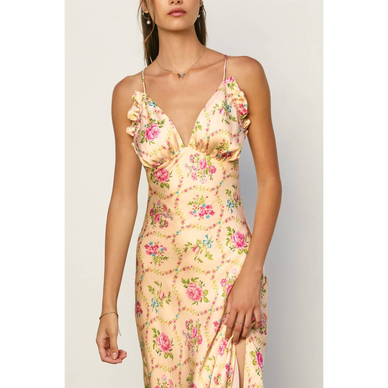 Woman wearing a floral satin slip dress with ruffled triangle bust detail in Eternal Afternoon Ruffled Triangle Bust Maxi Dress