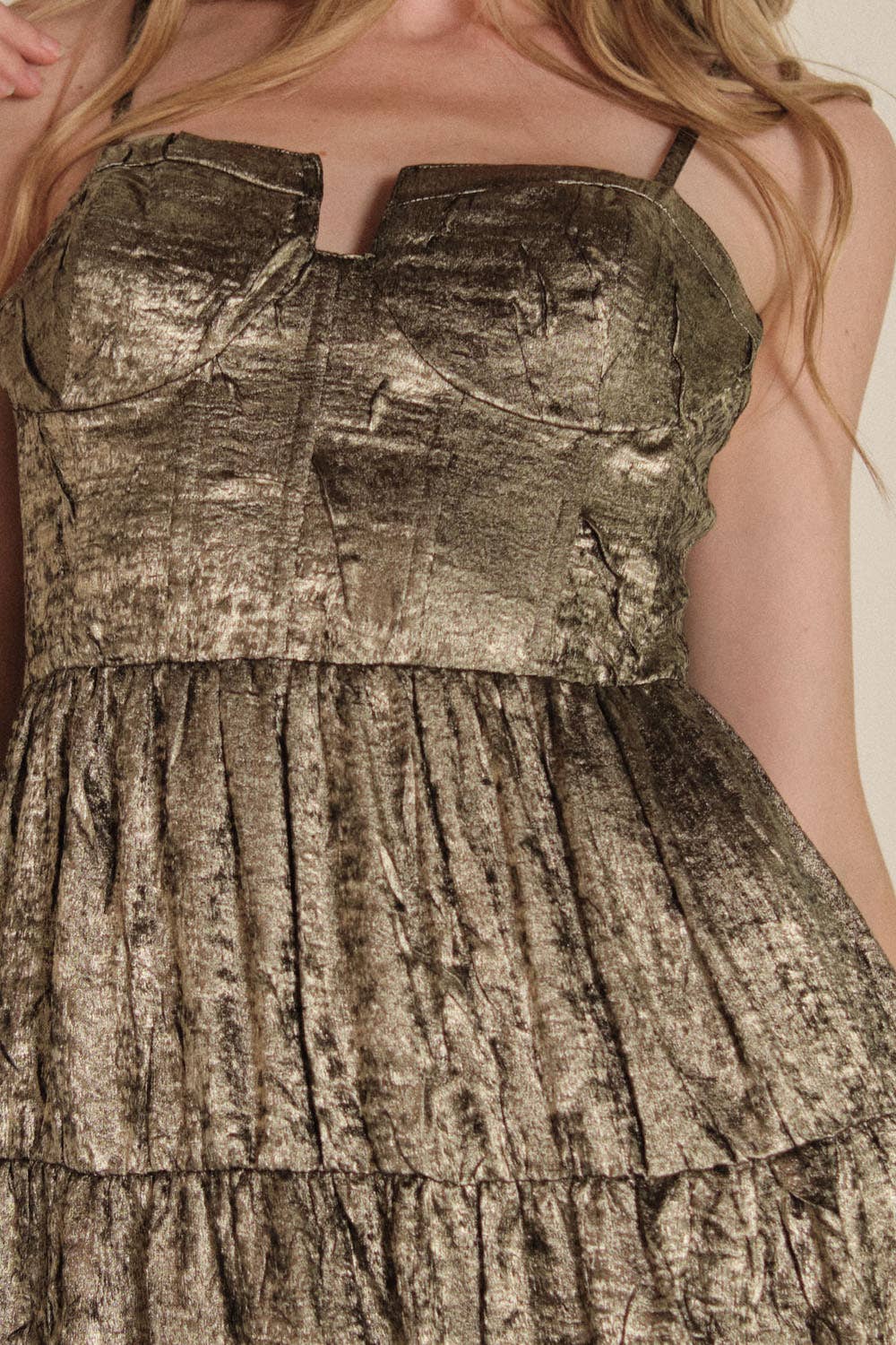 A close-up shows a woman wearing the Promesa USA Textured Metallic Fit-and-Flare Corset Maxi Dress, featuring a strapless corset bodice and pleated skirt. Only her torso and arms are visible, highlighting the dress’s elegant silhouette.