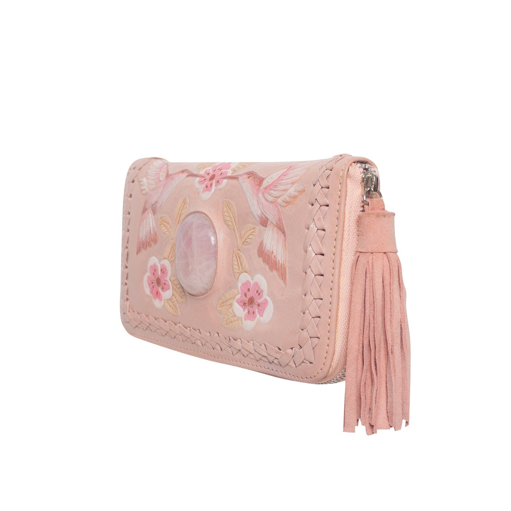 The Jodi Lee Queen Hummingbird Wallet Blush is a light pink bohemian clutch featuring floral embroidery, a large central oval stone, braided trim, and a matching pink tassel on the zipper.
