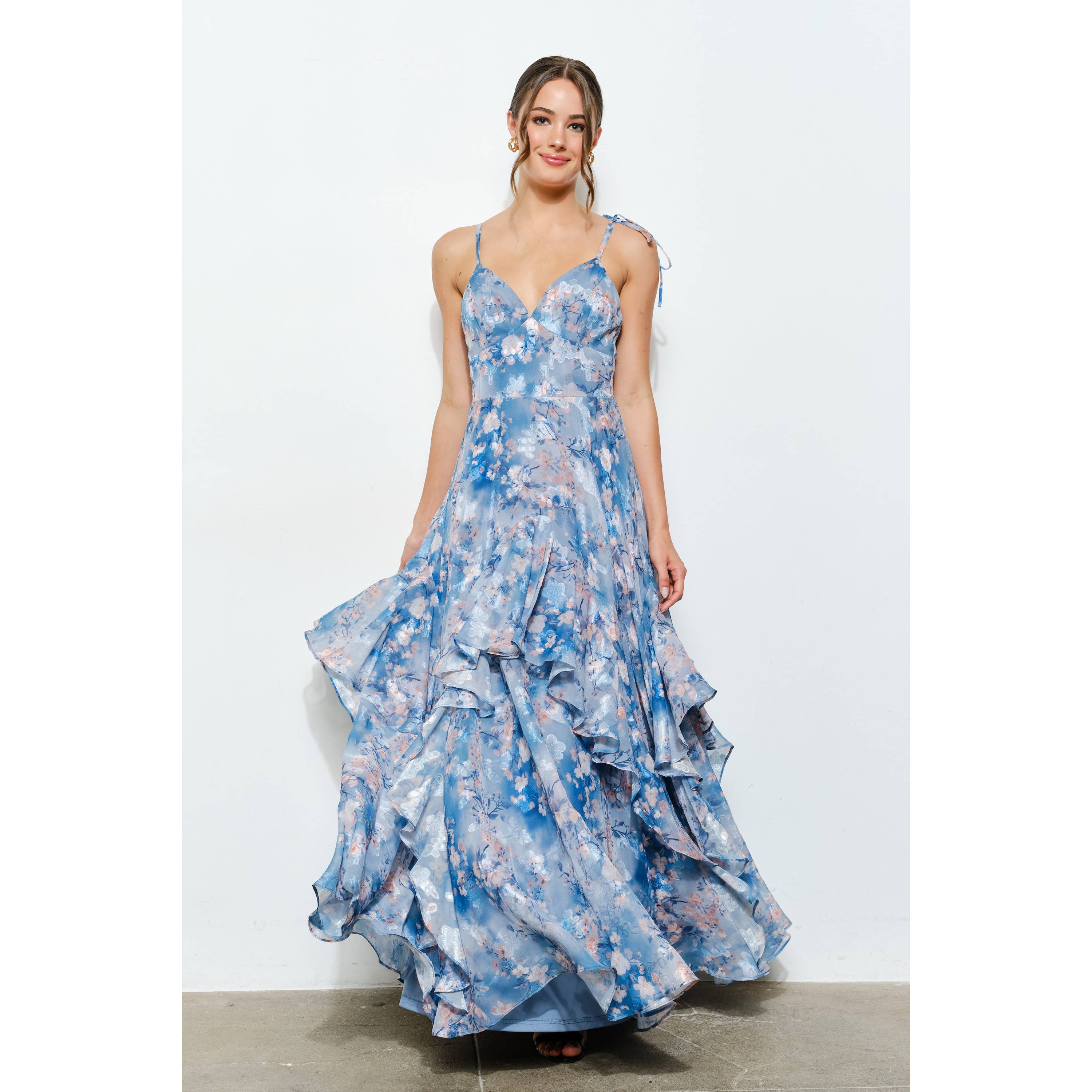 Woman wearing a flowing Romantic Floral Sweetheart Ruffled Maxi Dress in soft blue with floral print and ruffled layers