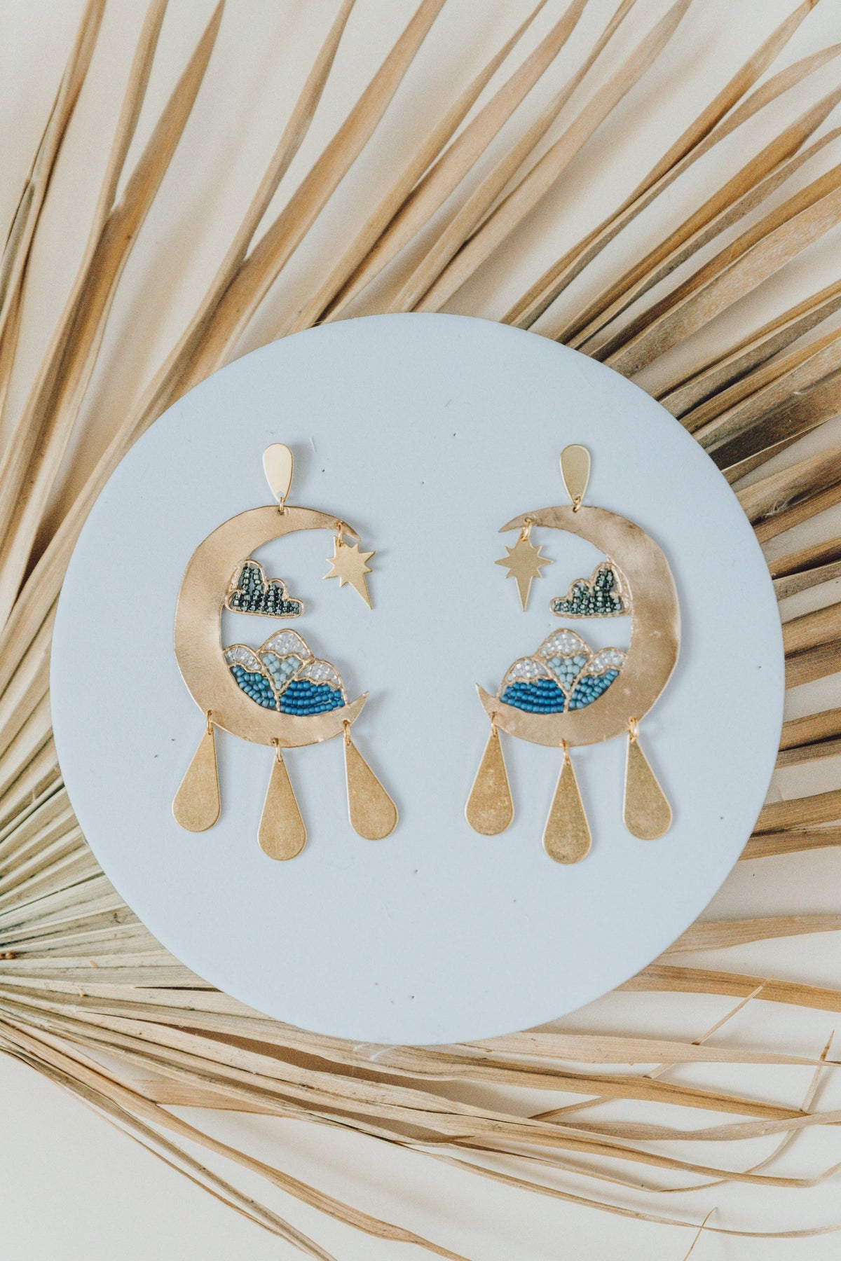 Moonscape Earrings with gold celestial designs blue bead accents and dangling teardops