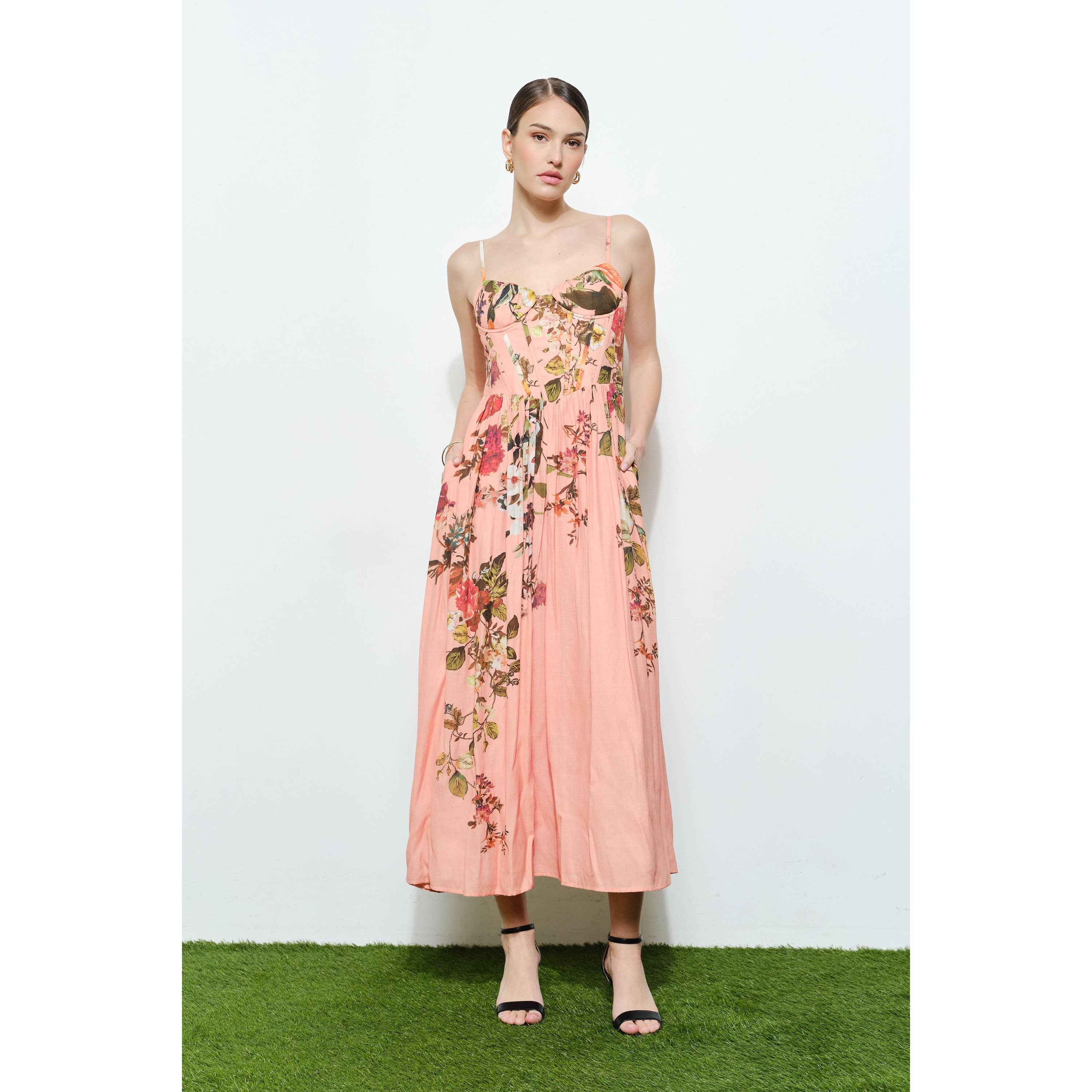Model wearing a blush pink Vintage Floral Sweetheart Maxi Dress with floral print and thin straps, styled with black heels.