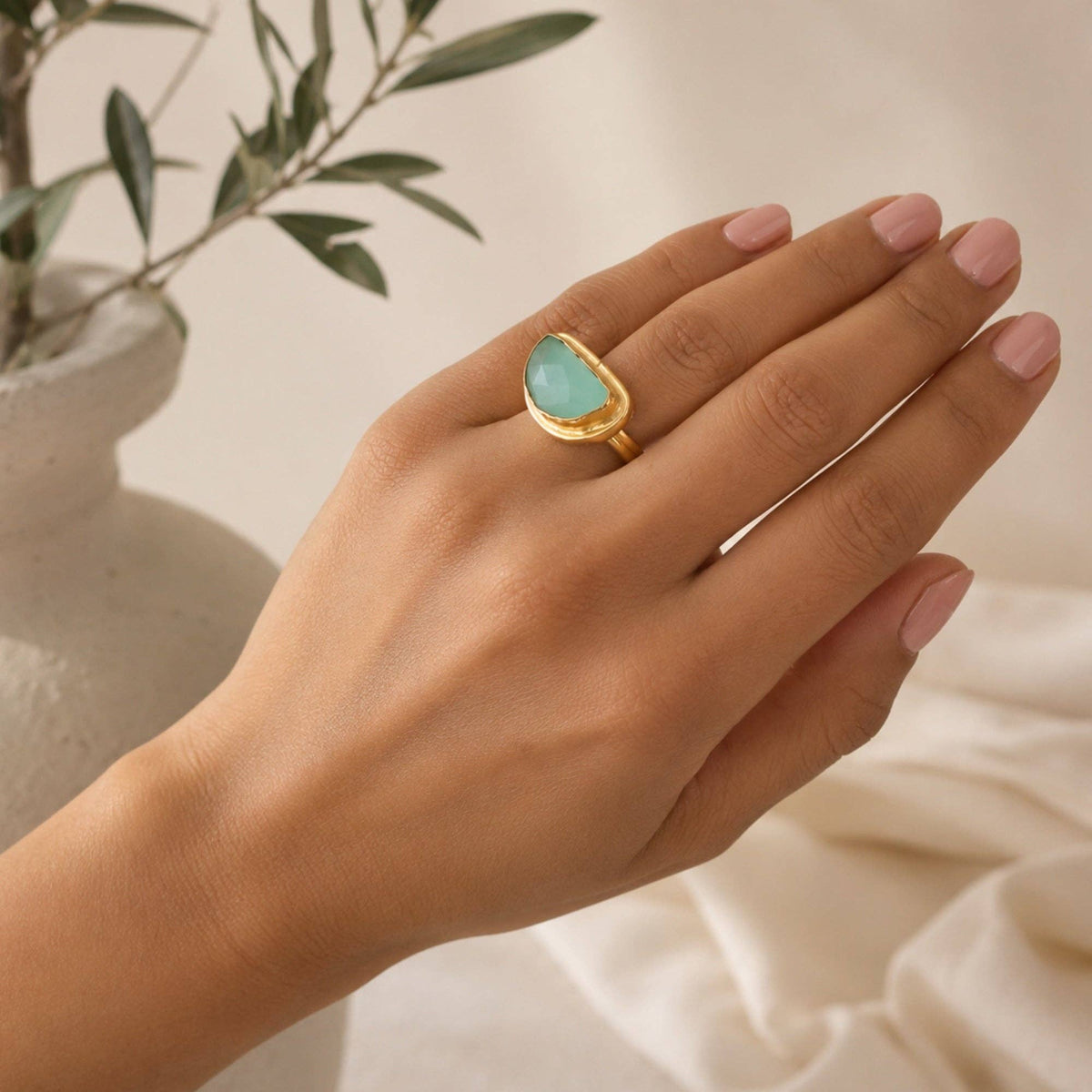 Aqua Chalcedony Semi-Circle Ring with gold tone band and aqua stone worn on hand