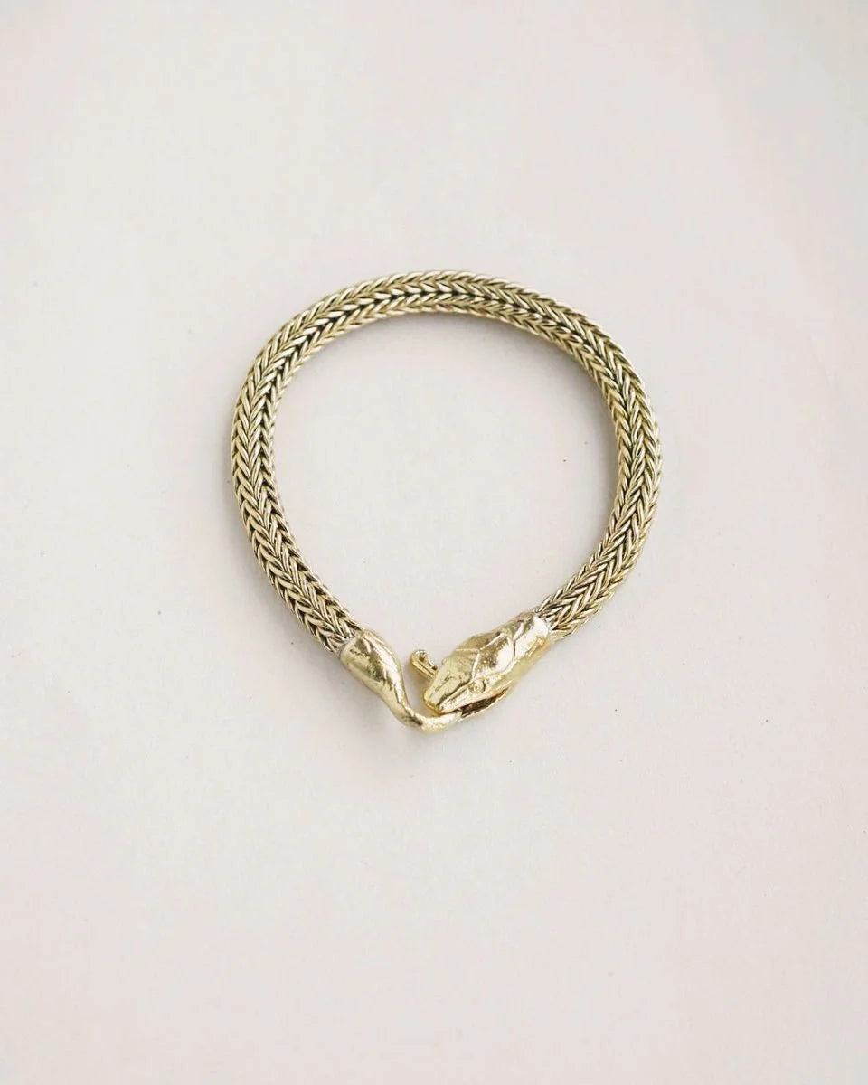 Serpent Bracelet with detailed snake head clasp in gold-tone, featuring intricate woven chain design for bold style.