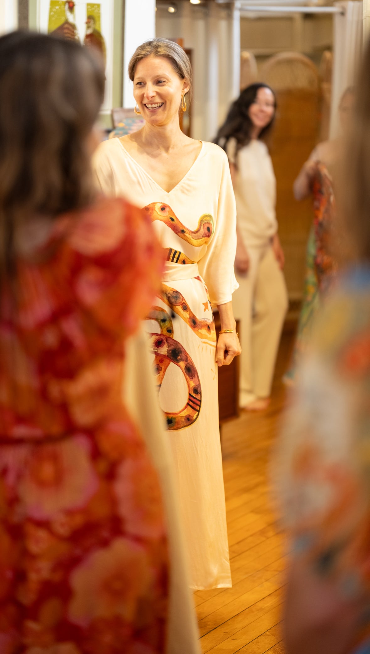 Woman trying on a dress with a snake pattern in a store