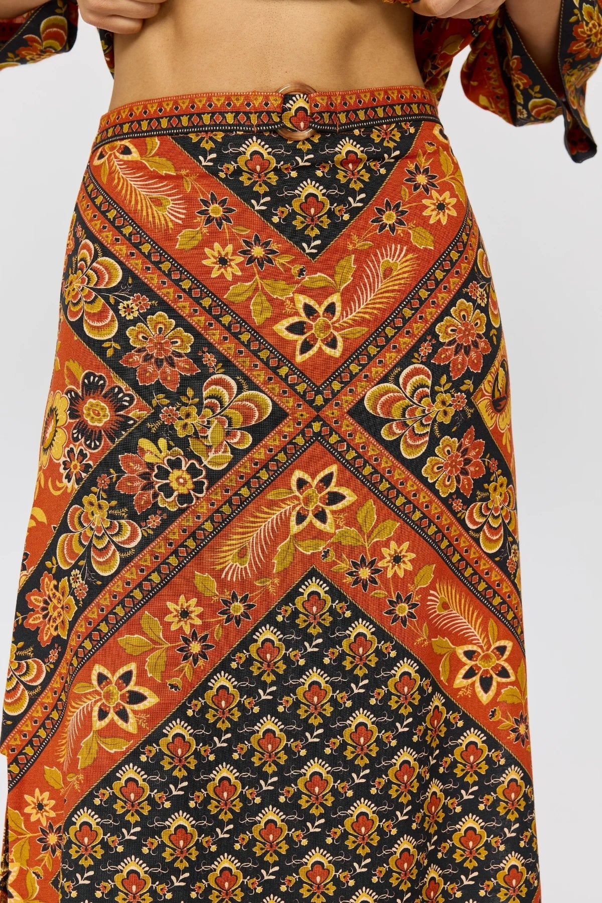 Whitney Skirt in Saffron featuring vibrant bohemian floral and geometric prints with a decorative waist buckle detail