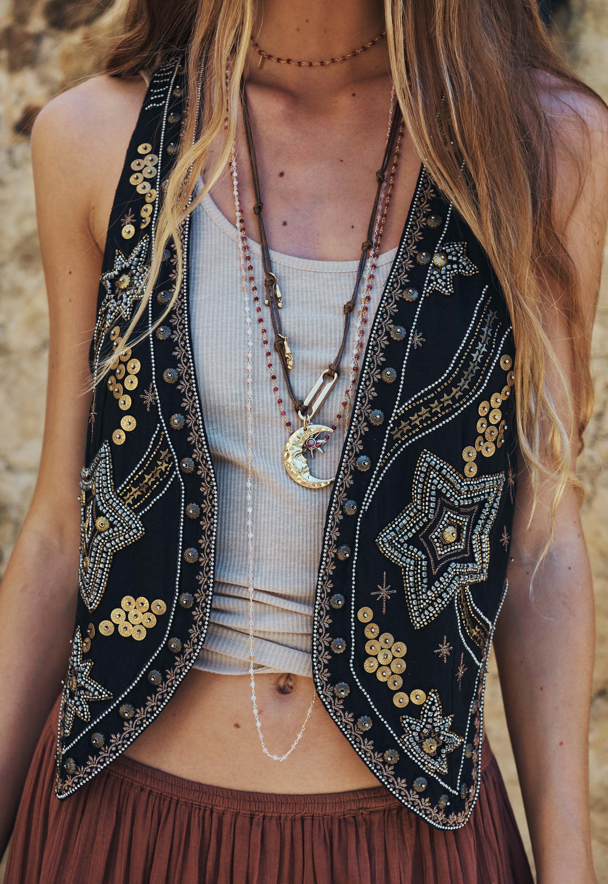 Close-up of woman wearing Spell Night Sky Vest – Midnight with detailed gold star embellishments and layered necklaces