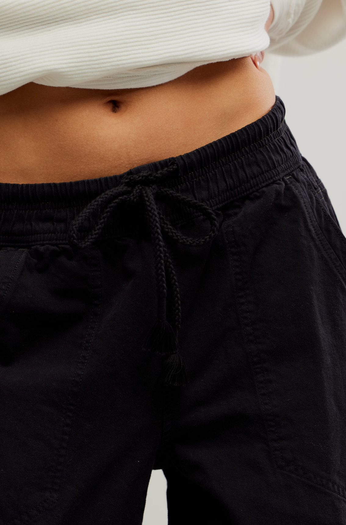 Close-up of a person wearing We The Free Easy Peasy Pull-On Jeans with a drawstring waist and casual fit.