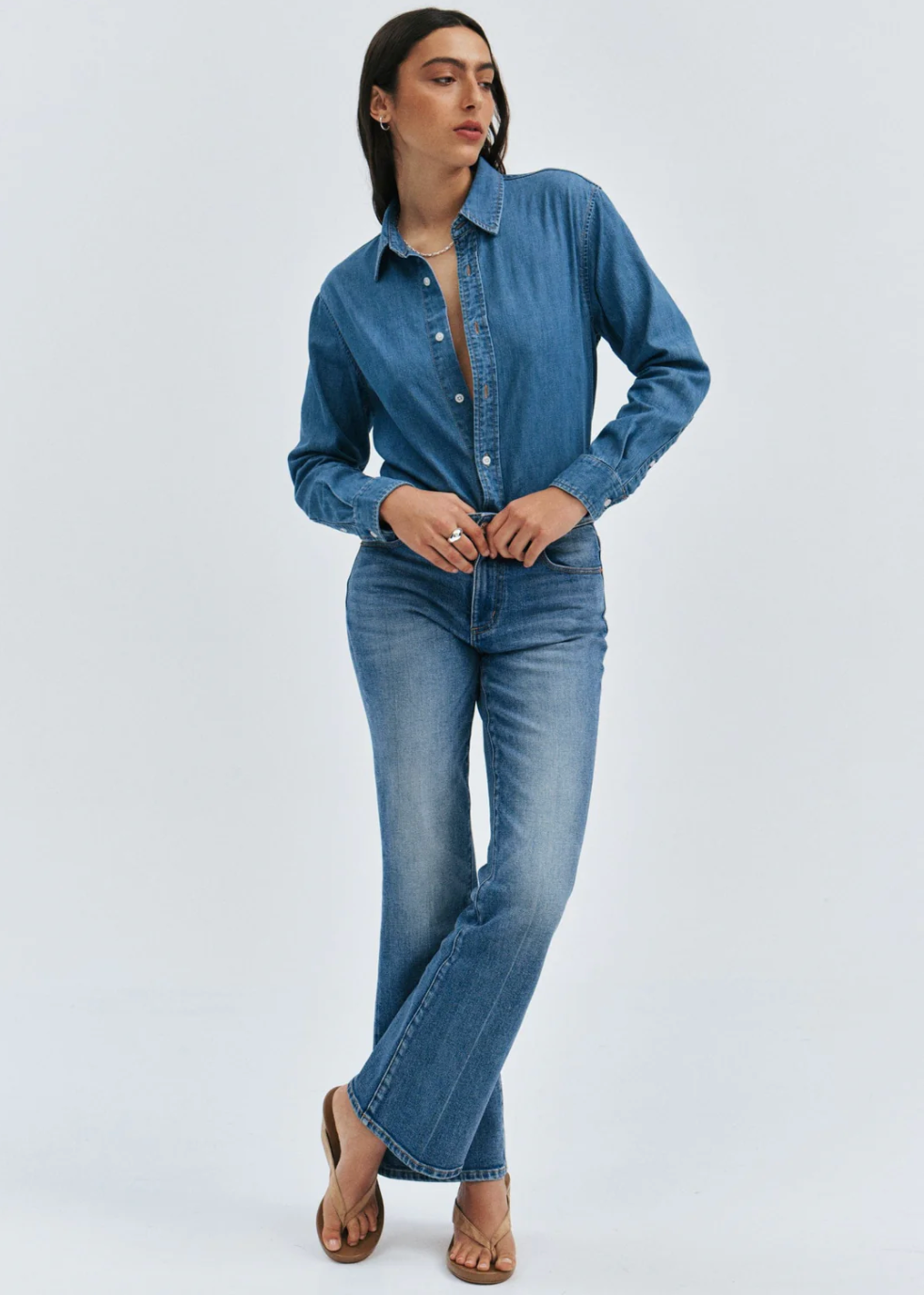 A woman wearing Rolla's Midtown Boot in Blue Iris paired with denim and a denim shirt in a relaxed pose.