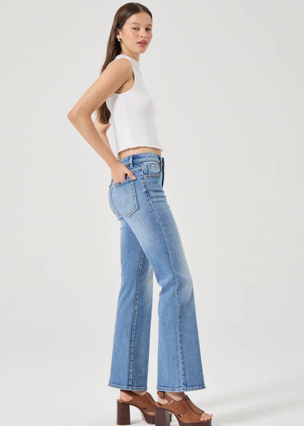 Woman wearing light blue denim jeans and brown platform sandals paired with a white sleeveless top and Rolla's Midtown Boot in Blue Iris