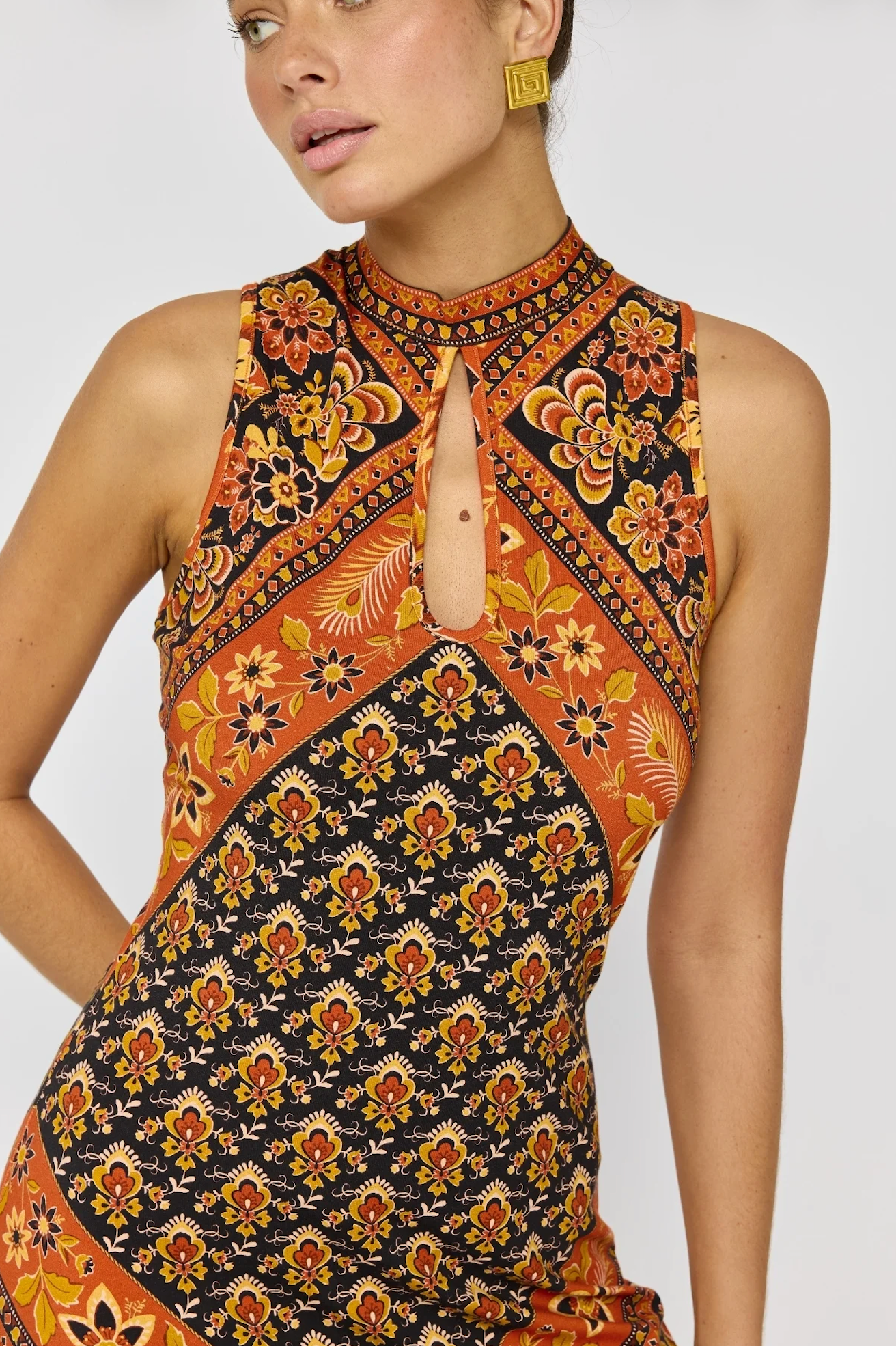 Close-up of a woman wearing Sydney Midi Dress in Saffron with vibrant floral patterns and a keyhole neckline.