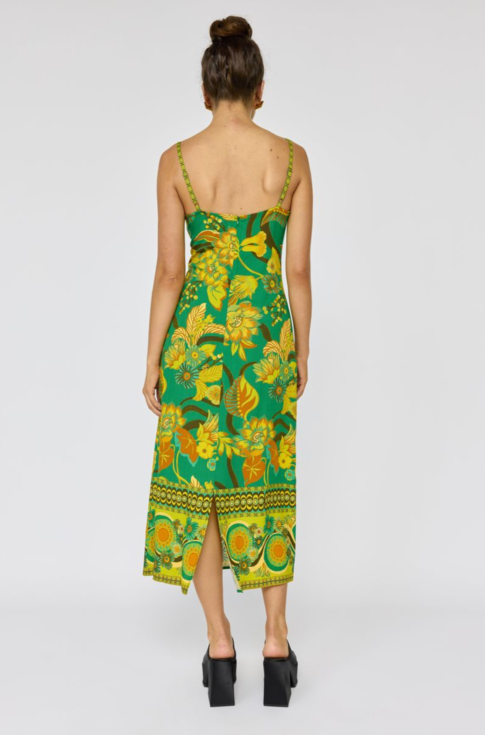 Woman wearing Martini Midi Dress in Absinthe with floral print and a back slit, styled with black platform heels