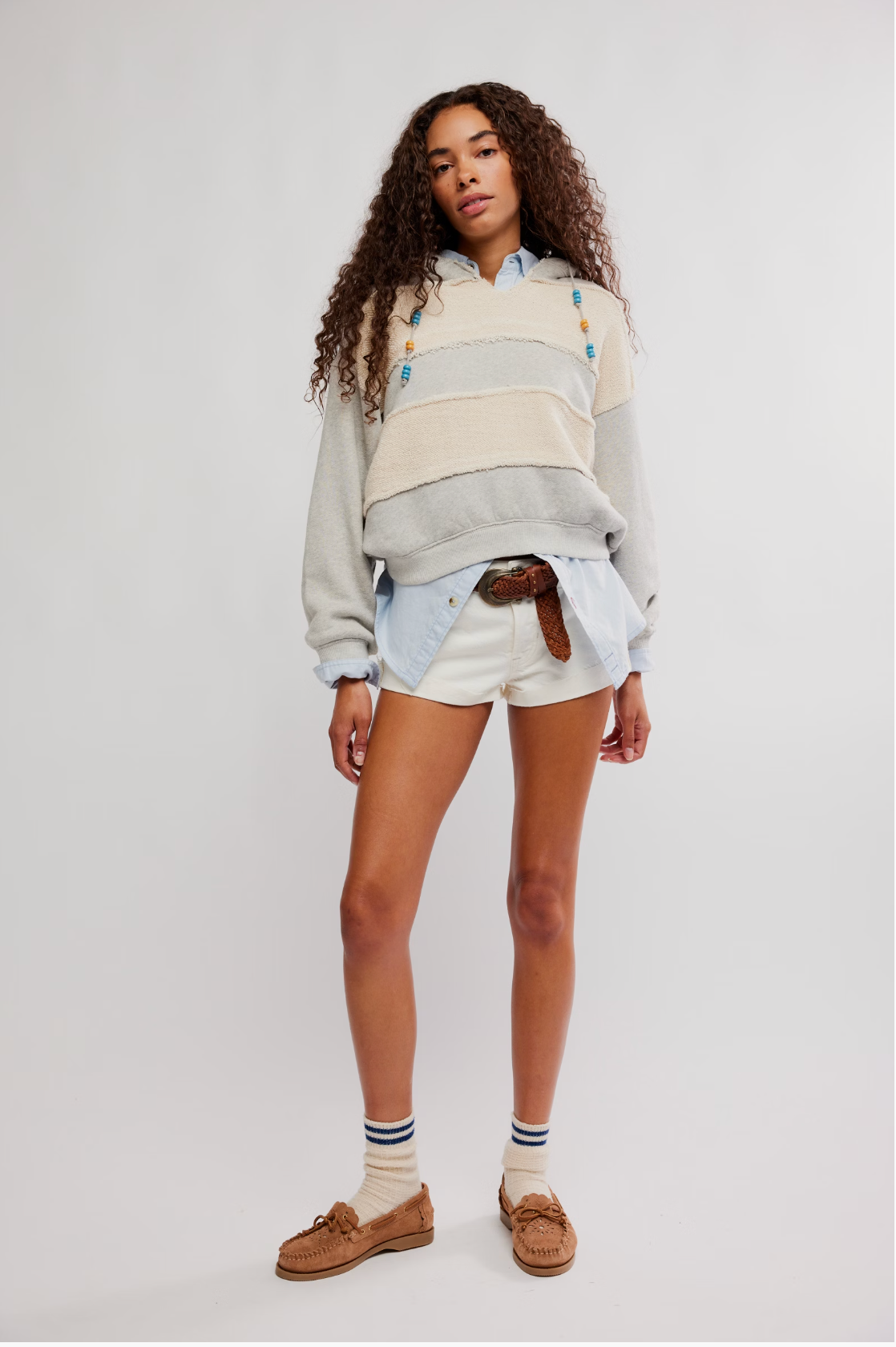 Woman wearing a layered look with shorts and the cozy Camp Crush Hoodie featuring textured stripes and bead drawstrings