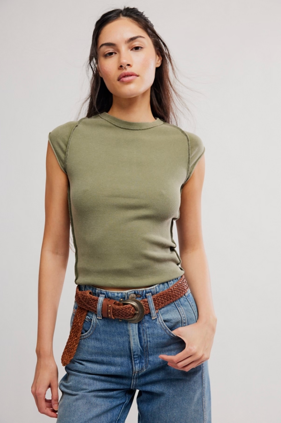 Woman wearing olive green sleeveless top paired with blue jeans and brown woven belt, showcasing We The Free Ever Had Tee in Adventurer