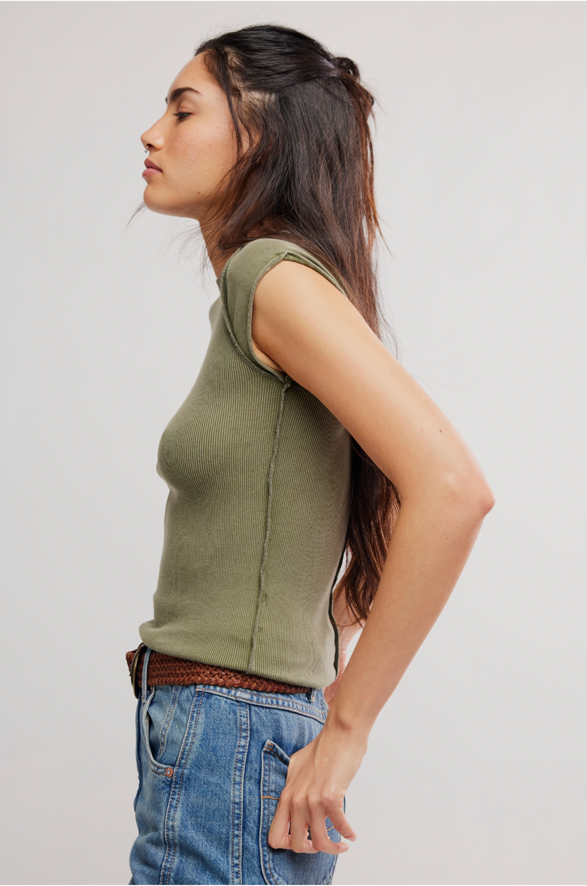 Model wearing We The Free Ever Had Tee in Adventurer, featuring a fitted, sleeveless, olive-green design styled with denim jeans.