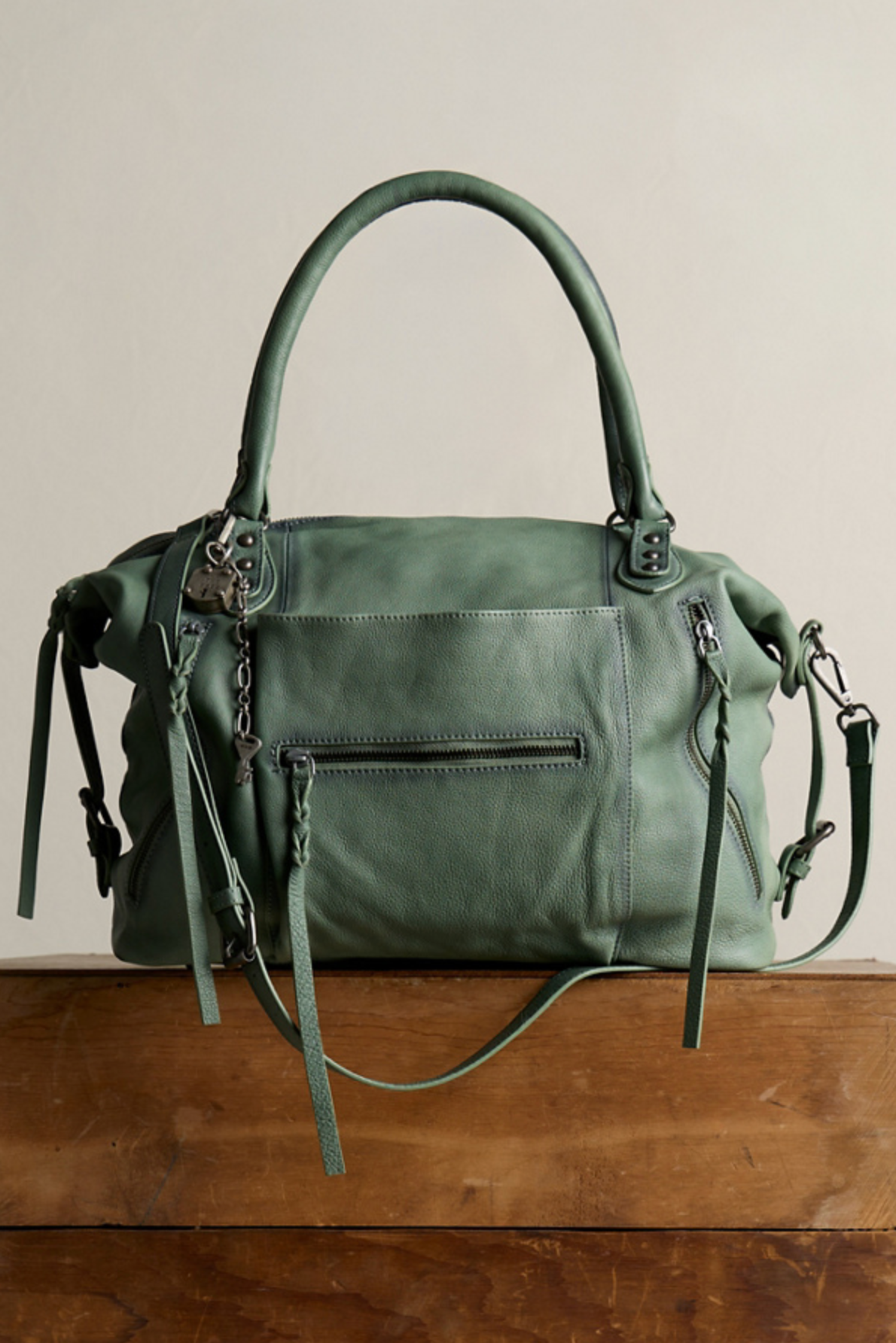 We The Free Emerson Tote Bag in Secret Sage with soft leather, multiple zipper pockets, and adjustable handles for versatile style.