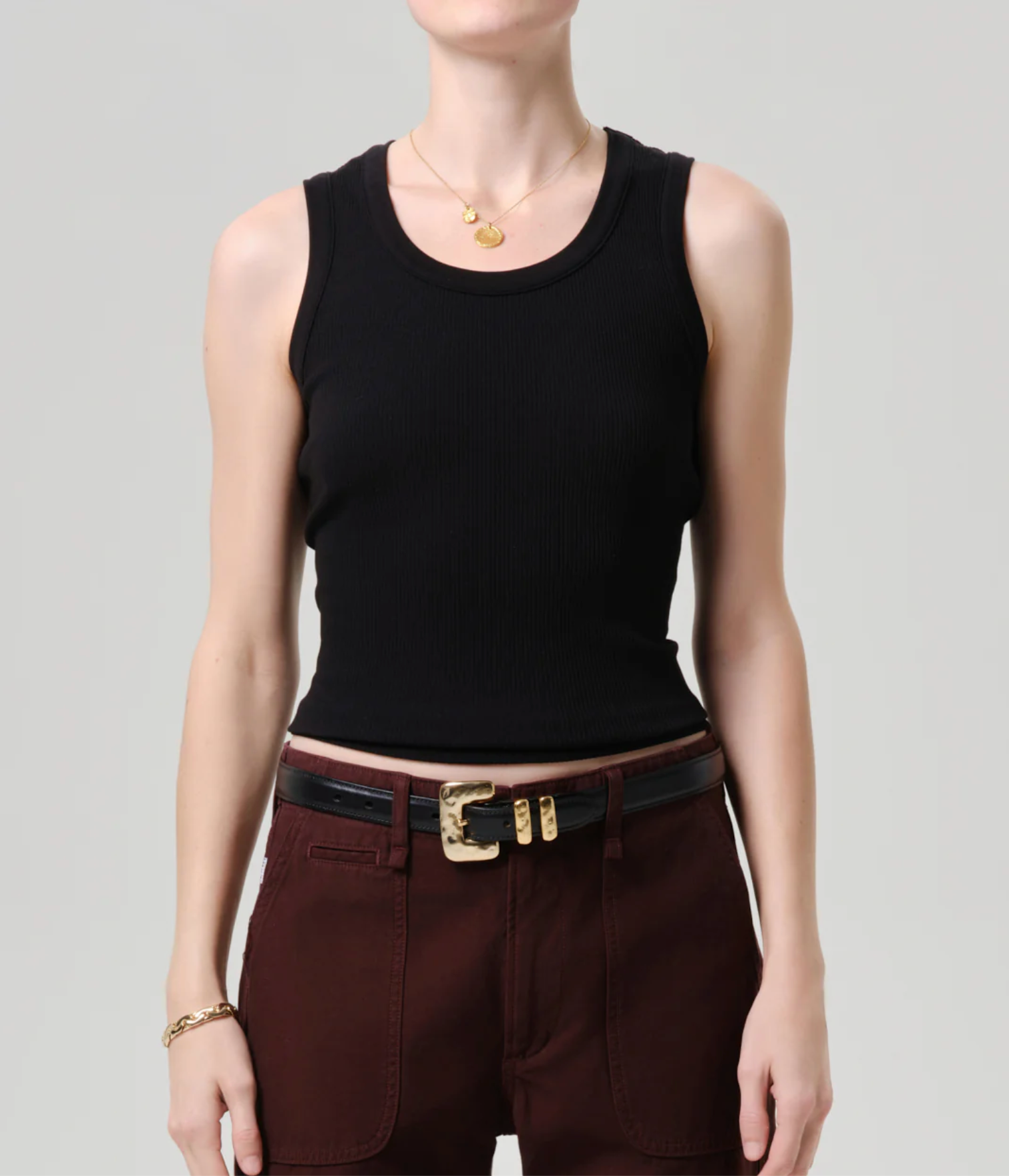 The Nova Tank by Citizens of Humanity in Black worn with gold jewelry, brown pants, and a black belt with gold buckle.