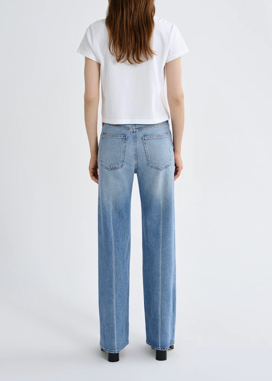 Back view of a woman wearing The Harper Jean in Outlook by Agolde, styled with a simple white cropped t-shirt.