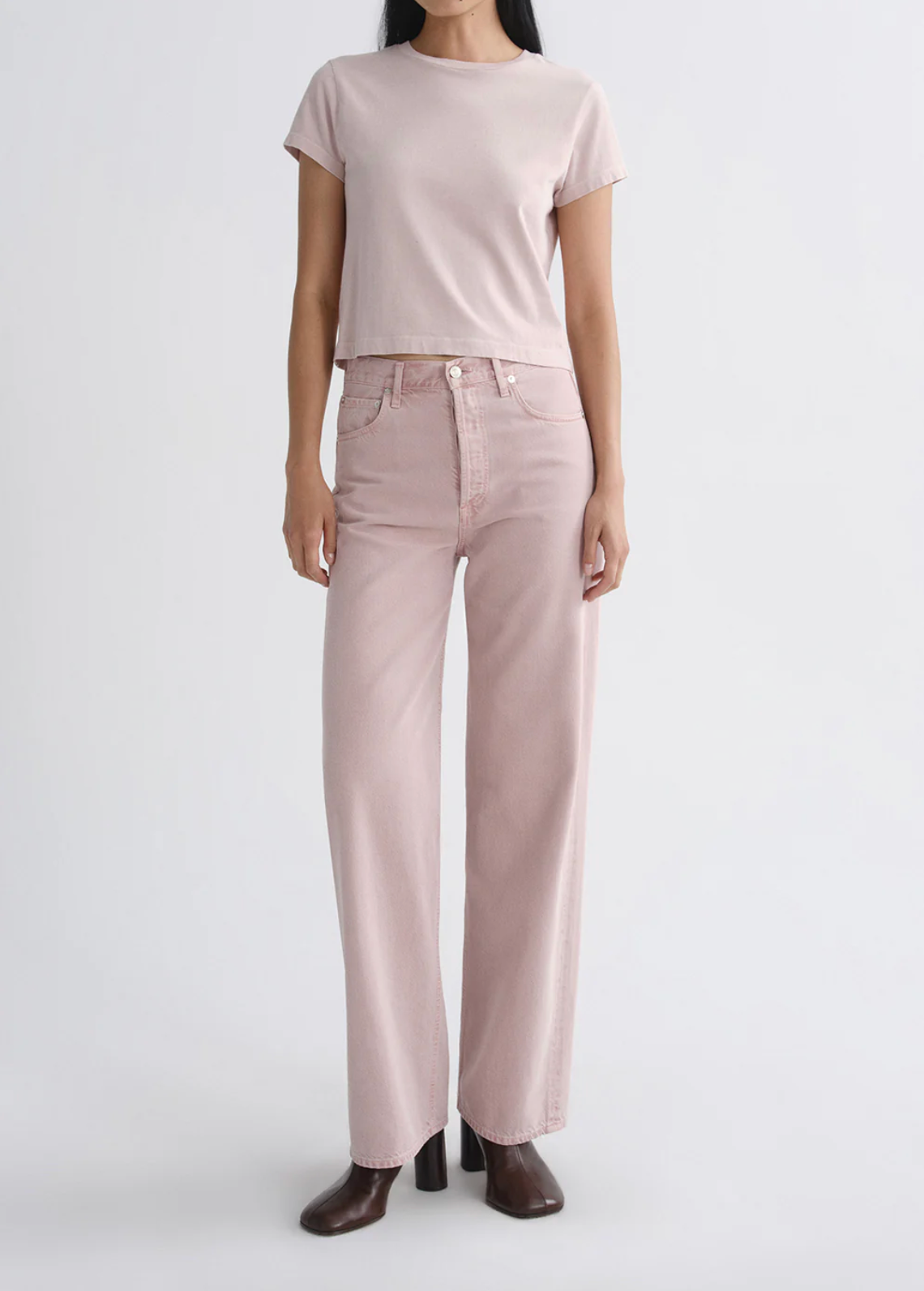 Woman wearing The Adine Shrunken Te in Wallflower by AGOLDE styled with a casual pink tee and brown ankle boots.