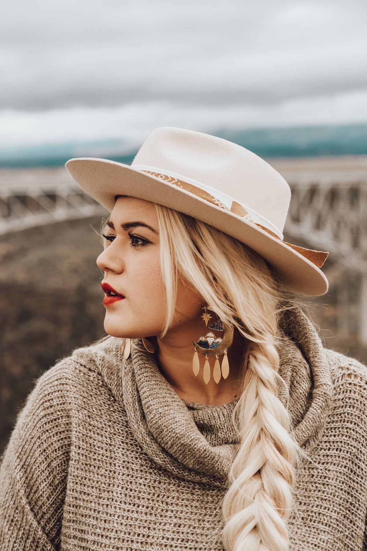 Moonscape Earrings worn by a woman in a cream hat and cozy knit sweater