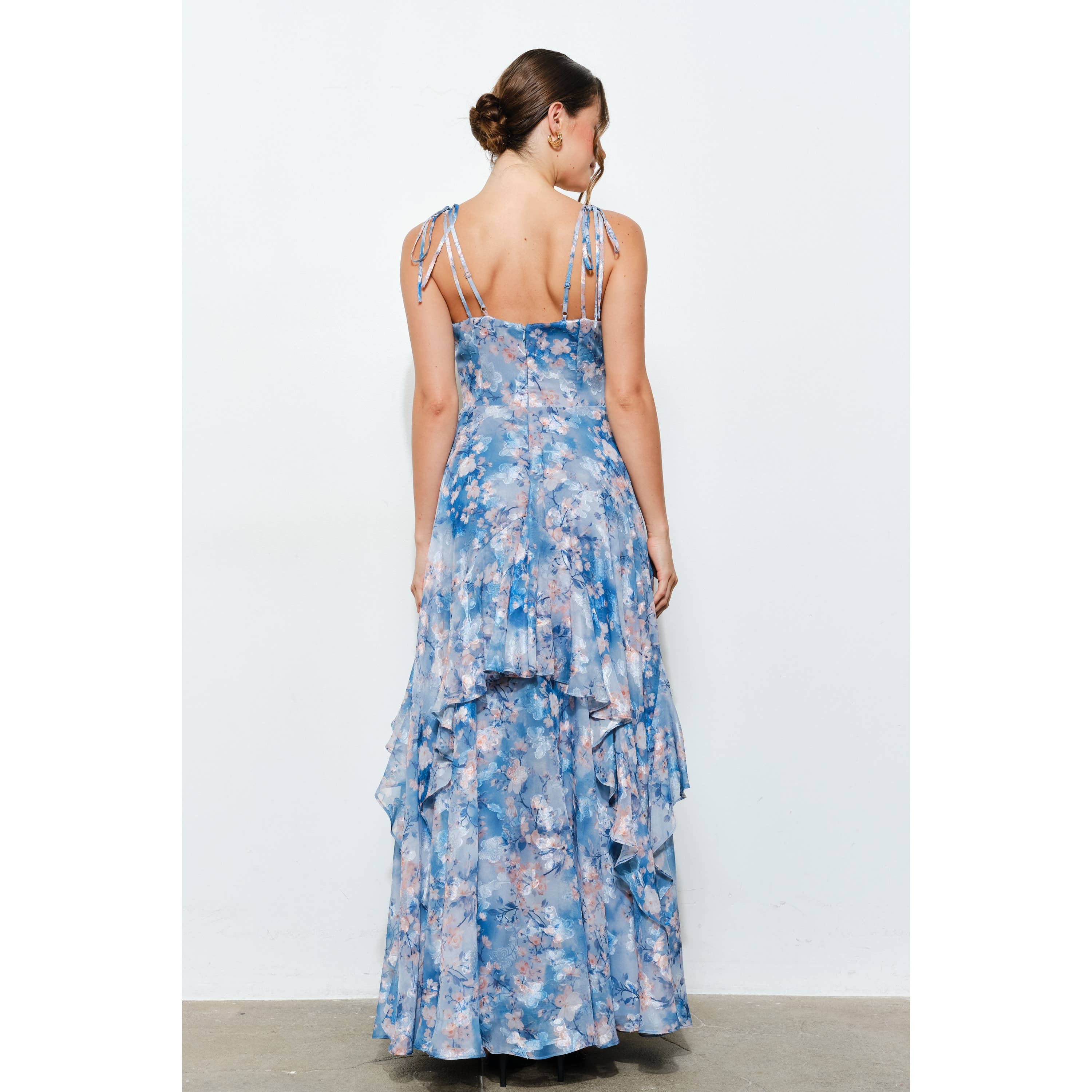 Woman wearing a Romantic Floral Sweetheart Ruffled Maxi Dress in soft blue floral fabric with delicate shoulder ties.