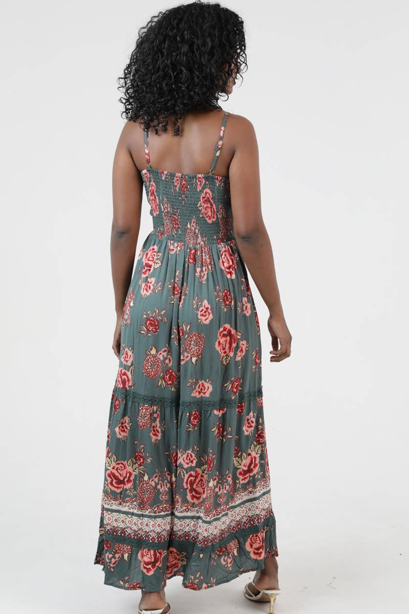 Woman wearing a floral patterned Golden Hour Twist Maxi Dress with adjustable straps and a tiered skirt design.