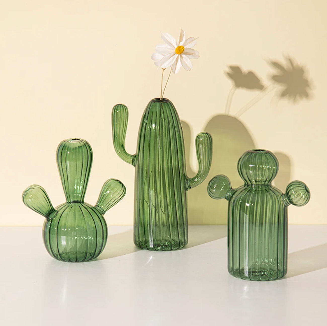 Three green Cactus Shaped Glass Hydroponics Plant Vase with textured ridges and one holding a white flower