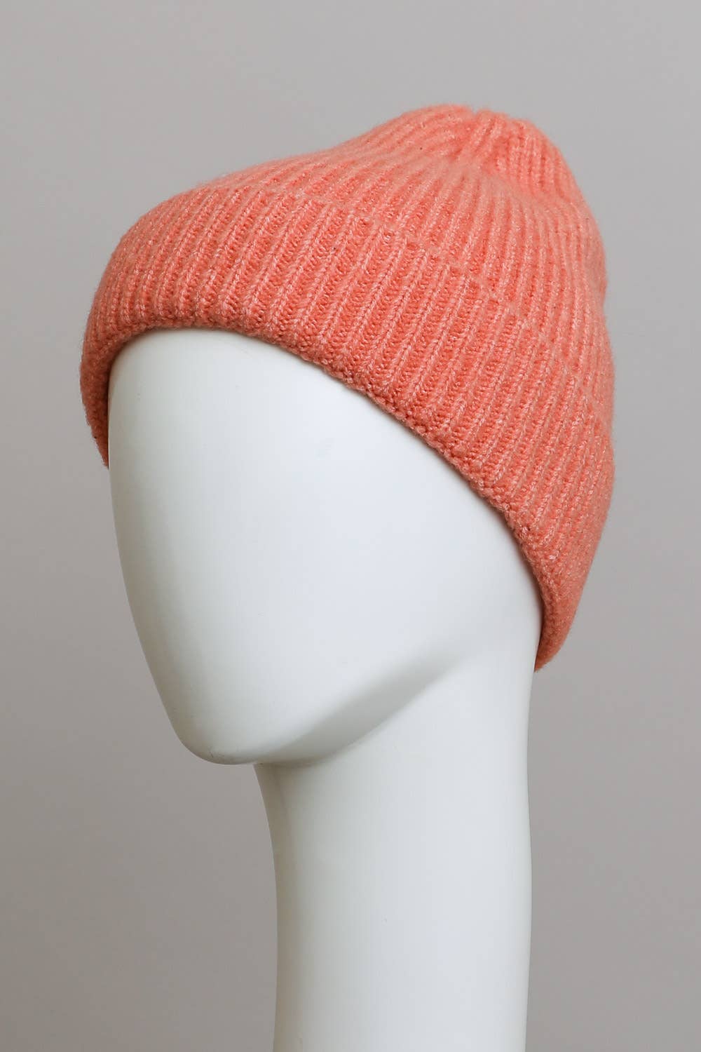 A white mannequin head displays the Leto Accessories Versatile Cuffed Beanie – Cozy Rib Knit Hat in light pink, set against a plain gray background—an ideal accessory for fall.