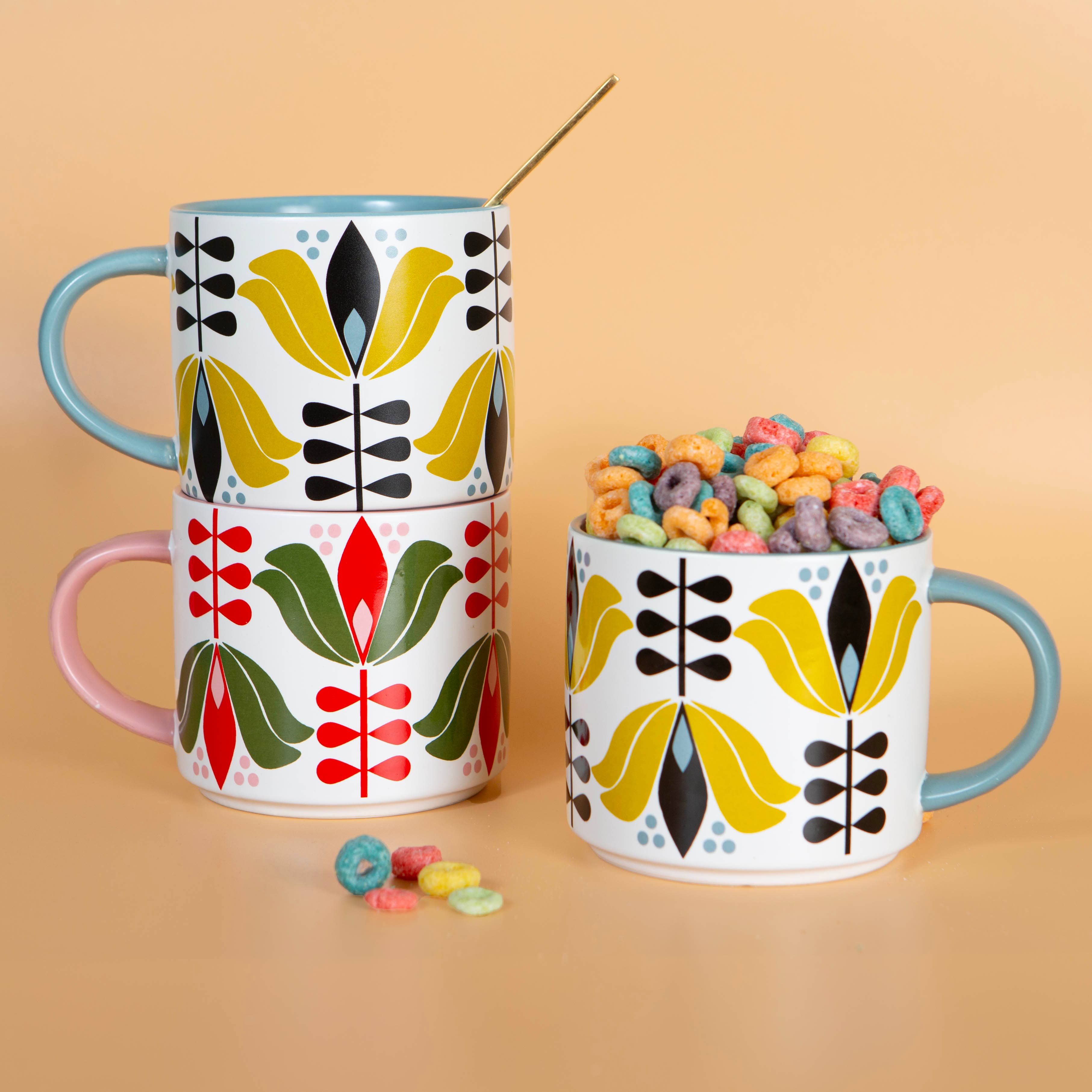 Yellow Lotus Flower Mid Century Stackable Matte Coffee Mug with colorful floral design and pastel handles stacked and filled with cereal