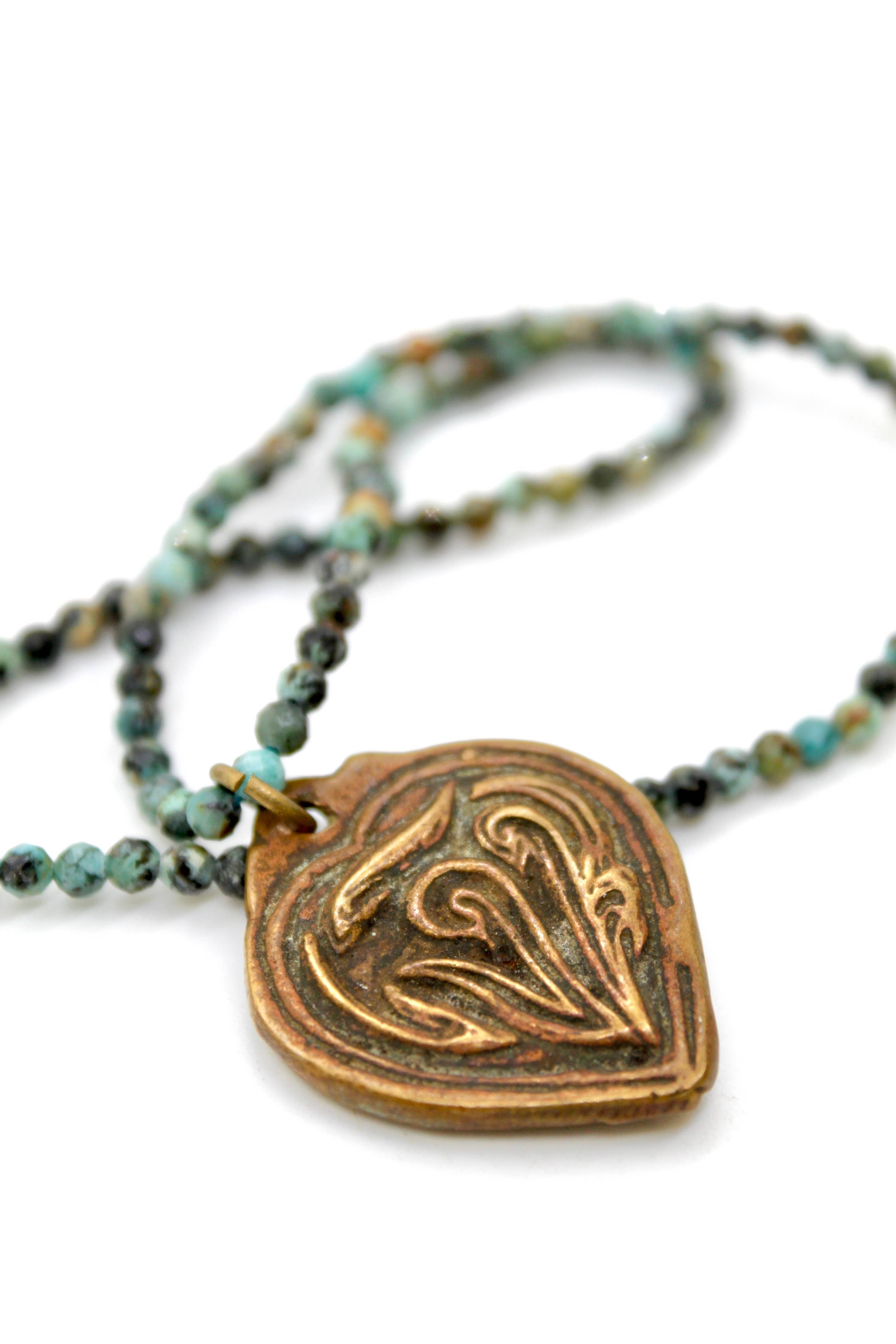 Buddha Necklace 117 - Faceted African Turquoise Necklace with a detailed brass pendant and blue-green stone beads.