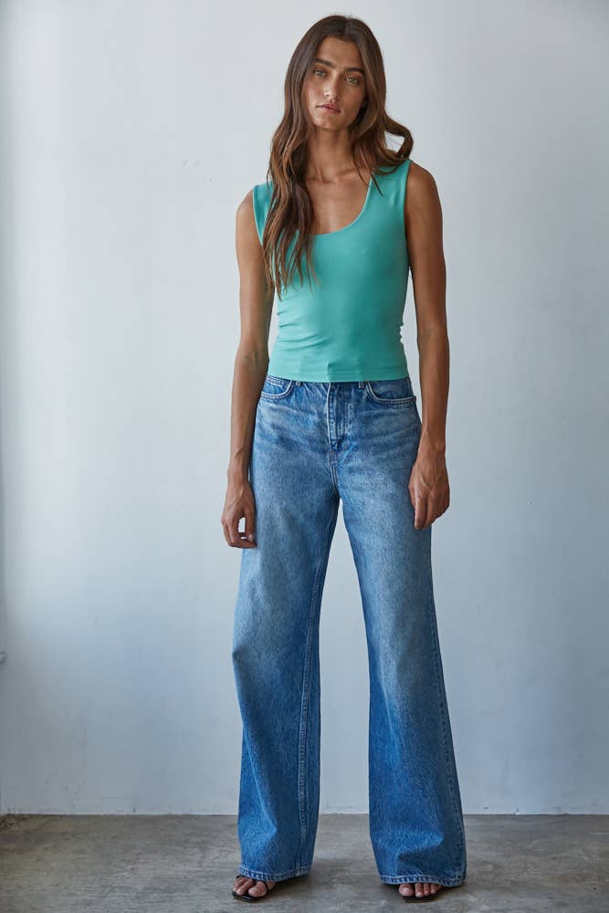 Woman wearing a teal Double Layered Seamless Top paired with wide-leg blue denim jeans and sandals