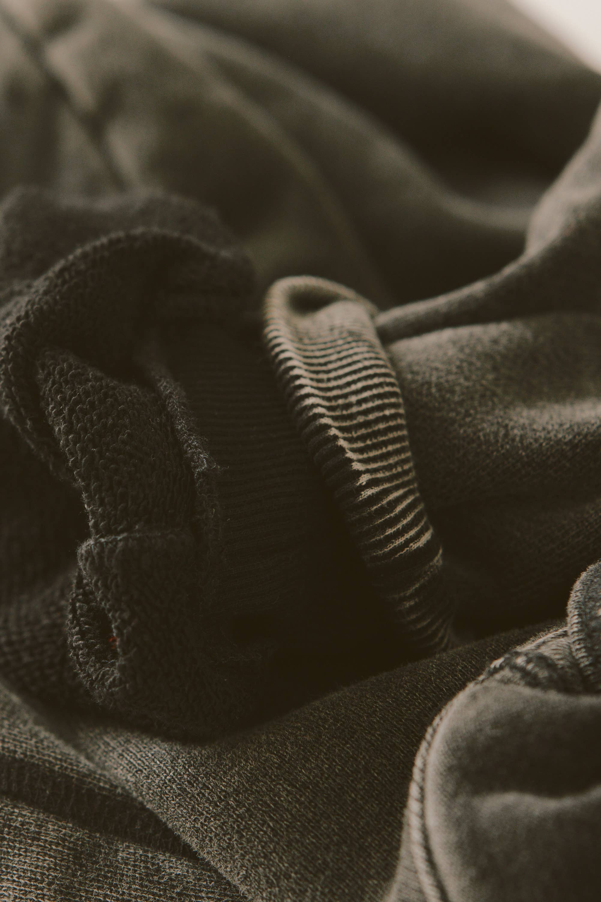 Close-up detail of soft textured fabric and ribbed cuff of the SORRY MOM HOODIE - PRESALE in muted tones.
